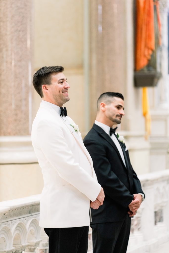 Boston wedding ceremony at Boston's Basilica groom smiles as he waits for his bride
