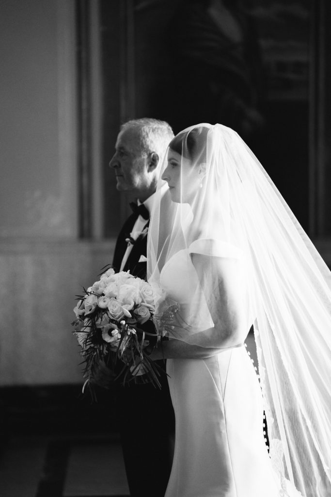 Boston wedding ceremony at Boston's Basilica black and white of bride and dad waiting arm in arm to walk down the aisle