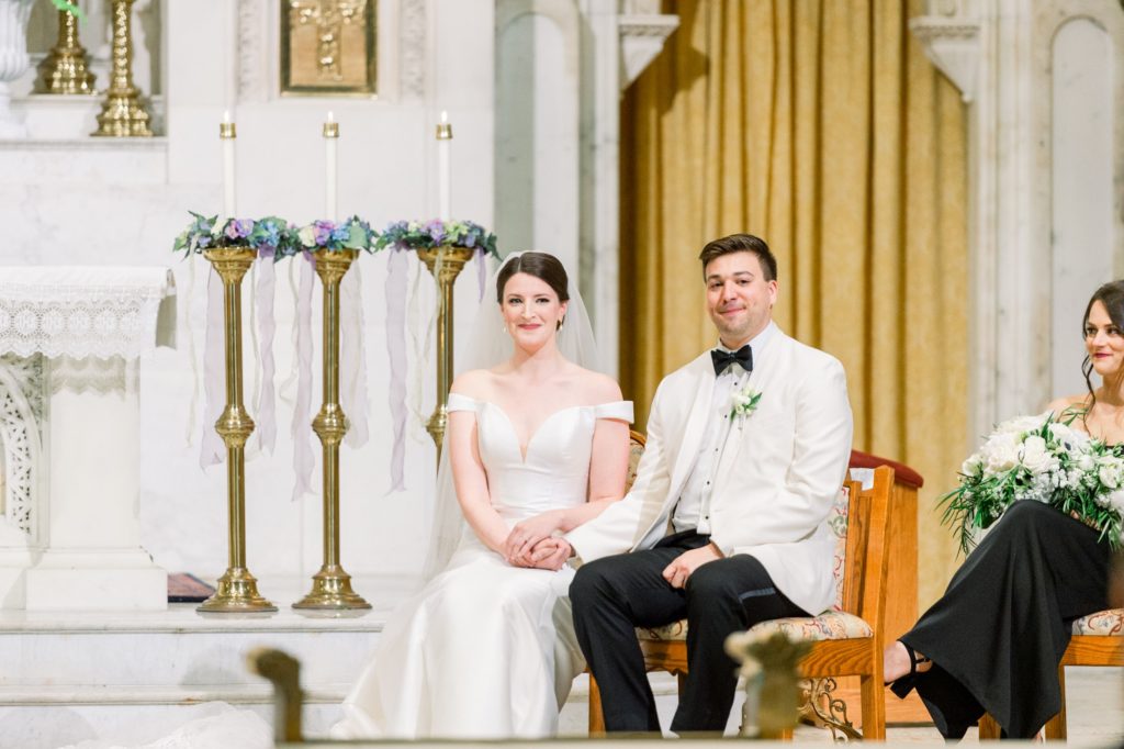 Boston wedding ceremony at Boston's Basilica bride and groom sit holding hands