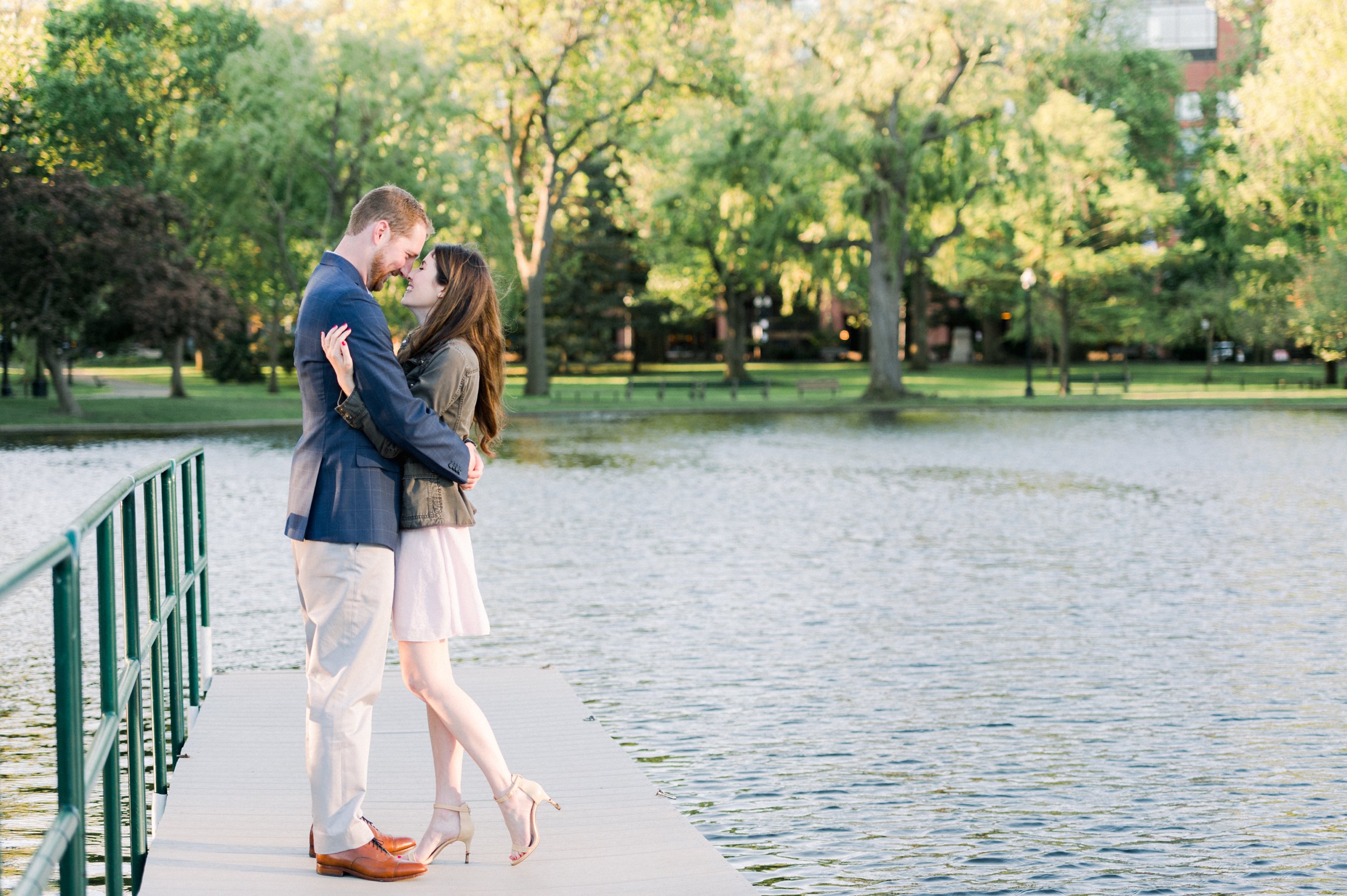 Spring engagement at sunrise in Boston Public Garden couple snuggles by the water