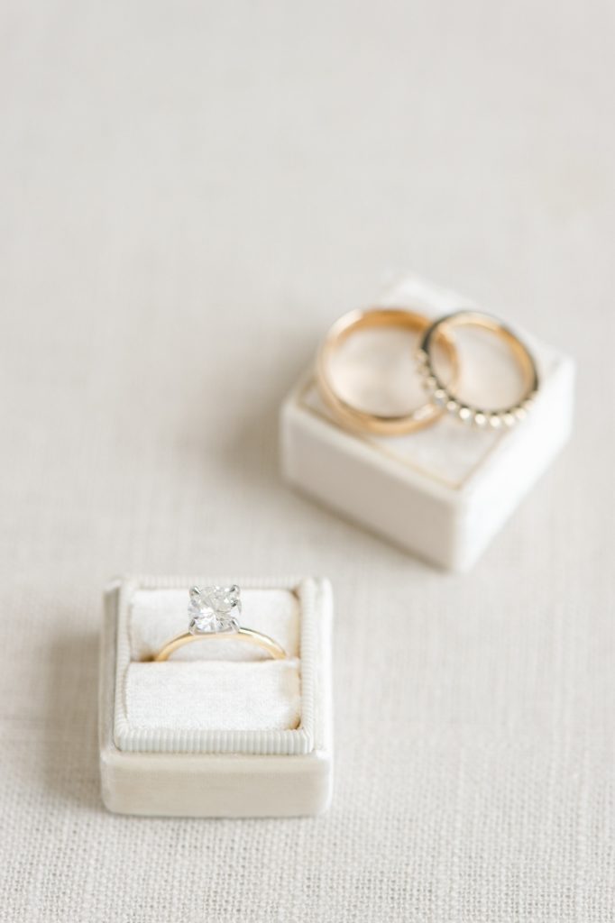 styled bridal flat lay of wedding rings and engagement ring on velvet ring box