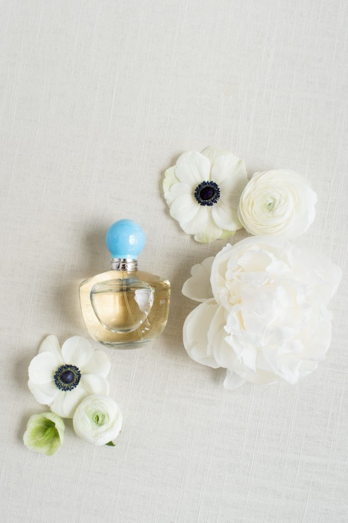 styled bridal flat lay of something blue perfume bottle with flowers
