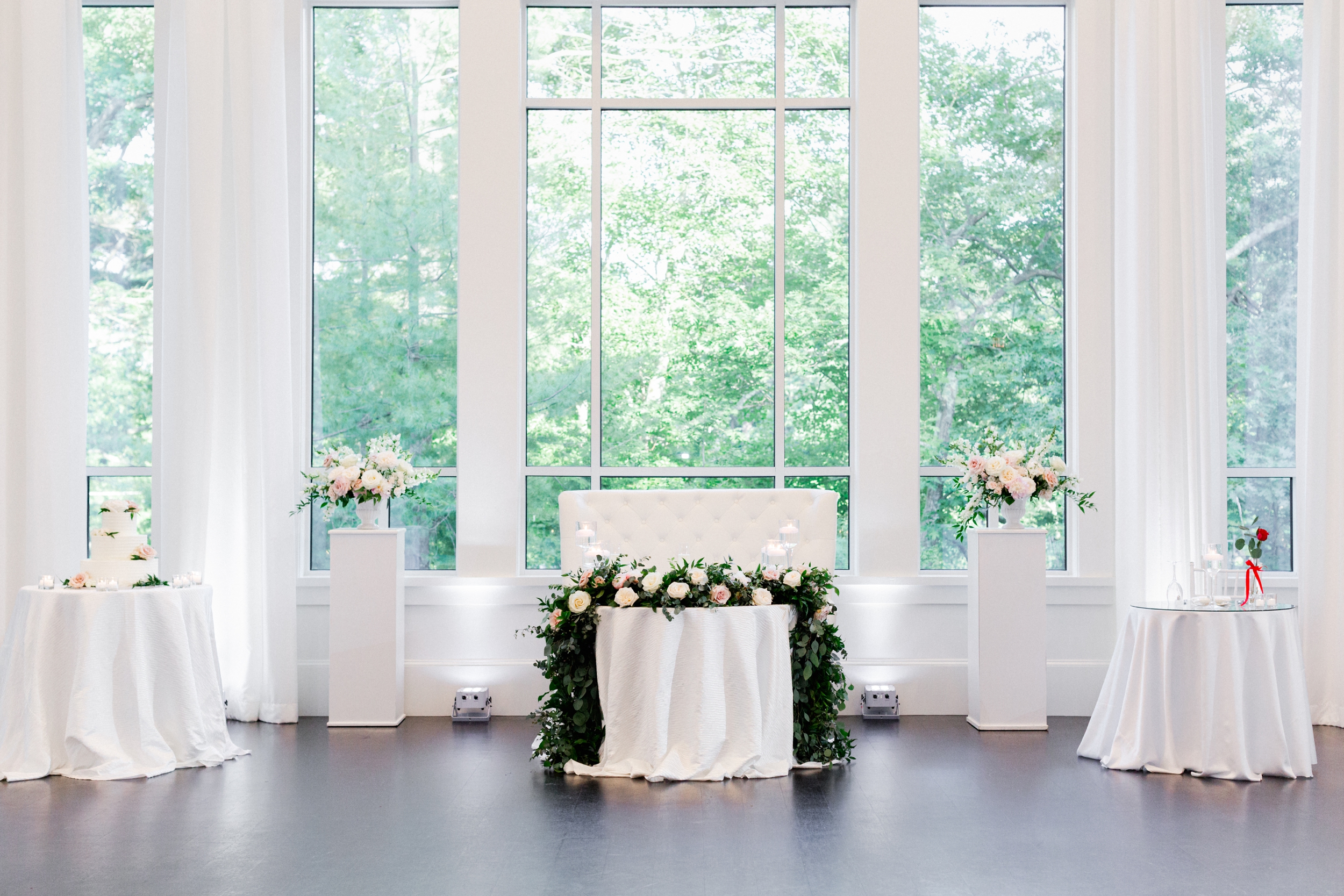 lush blush and greenery floral garland draped over sweetheart table with candles at Lakeview Pavilion wedding