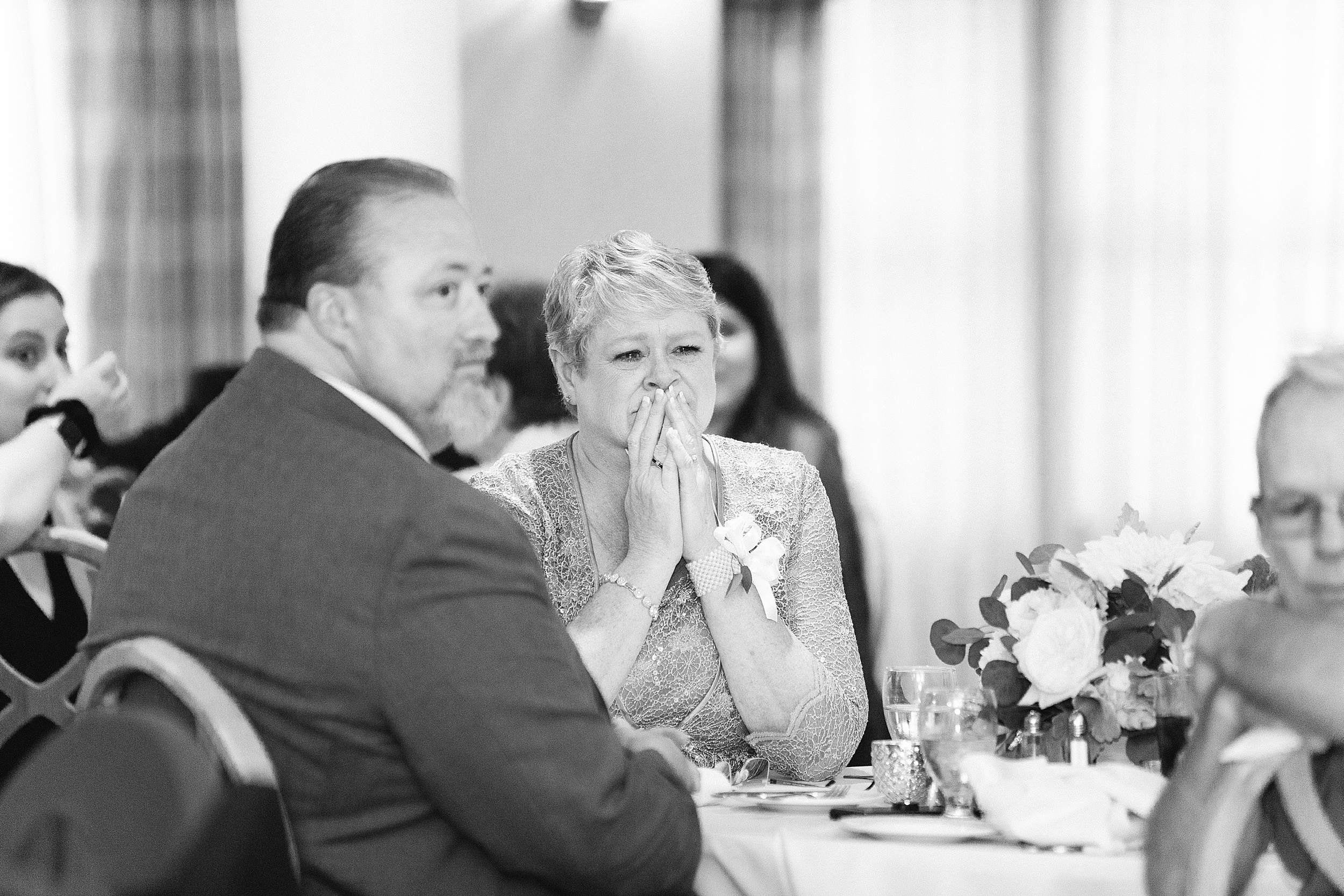 mom of bride looks on emotionally during maine wedding reception