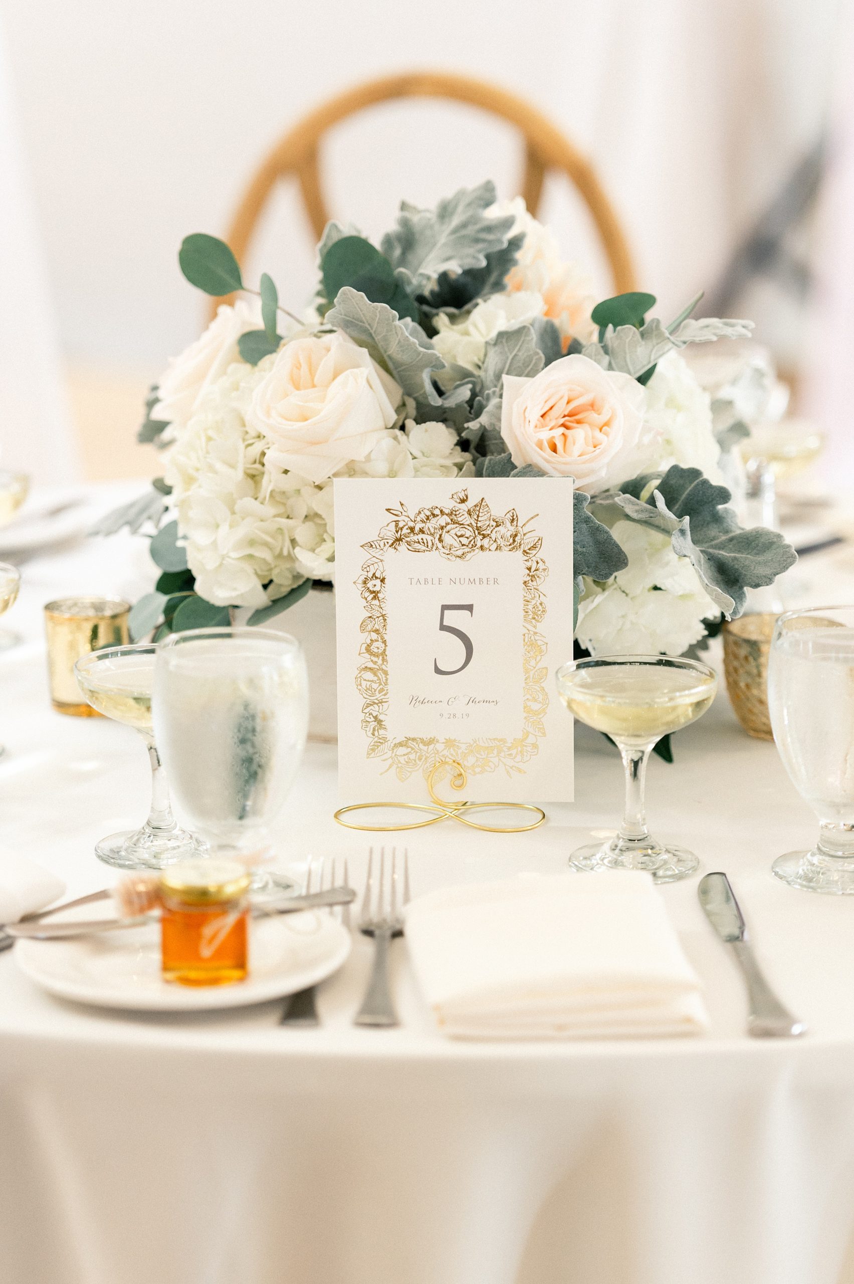 floral centerpieces and honey favors at york maine wedding with gold foil table numbers