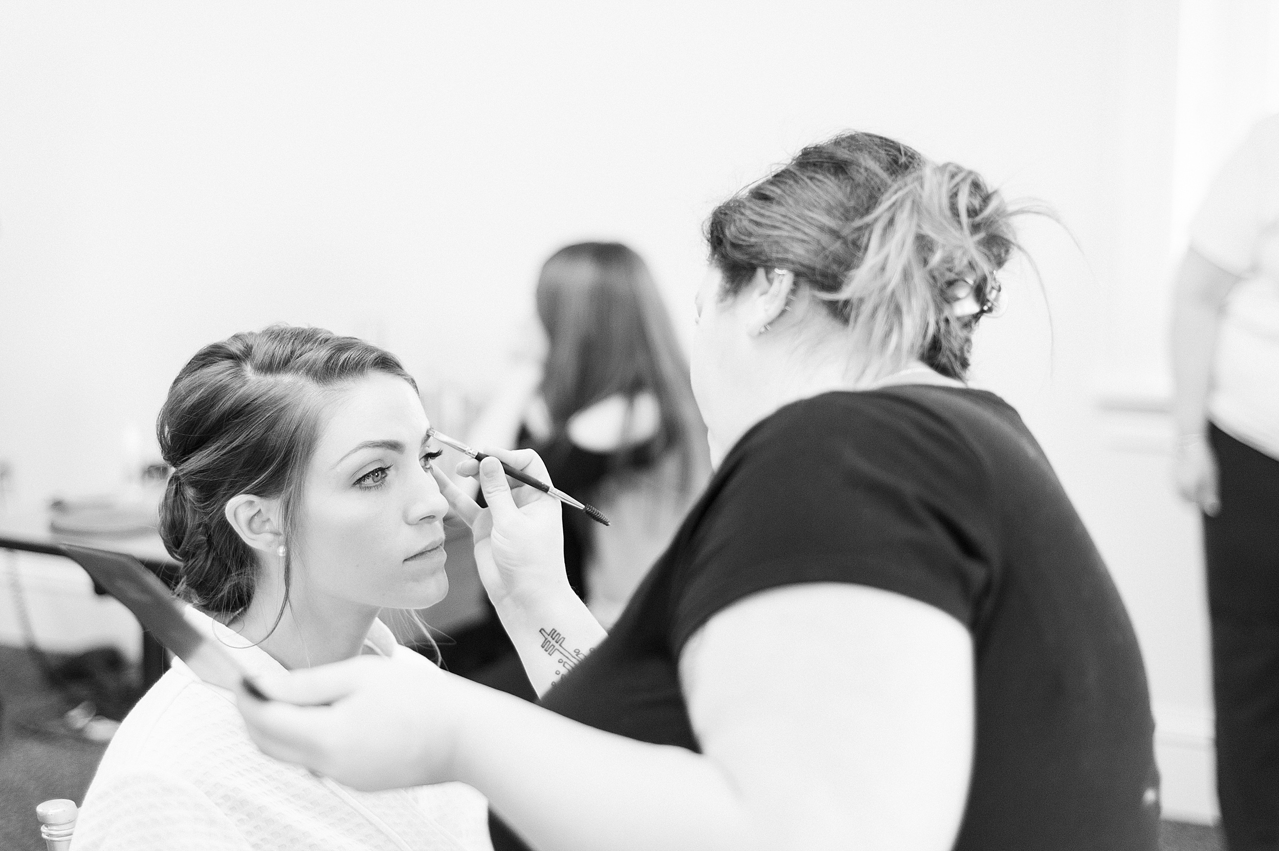 black and white of bride getting makeup done for wedding in Beverly MA