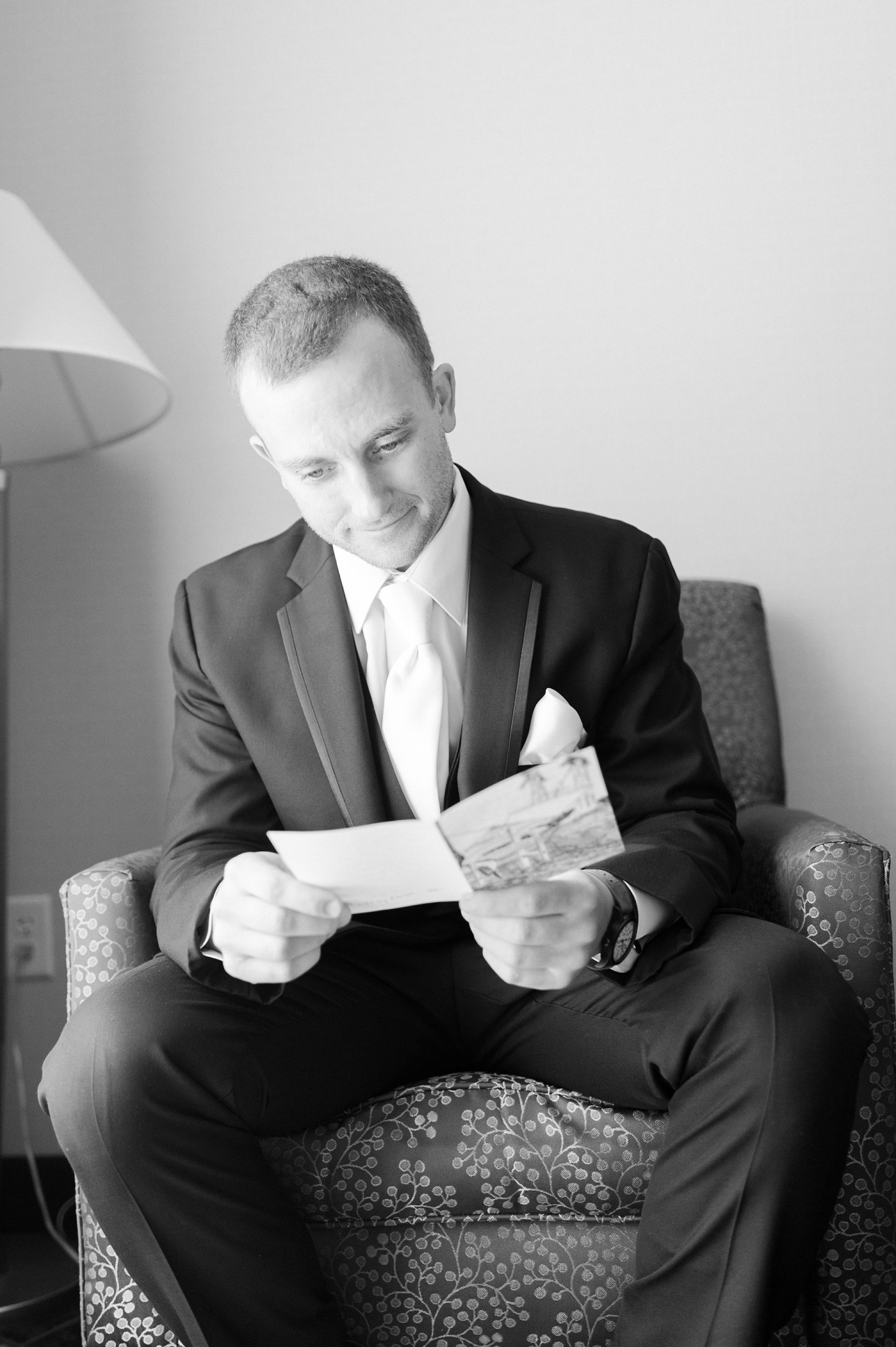 black and white groom opens note from bride