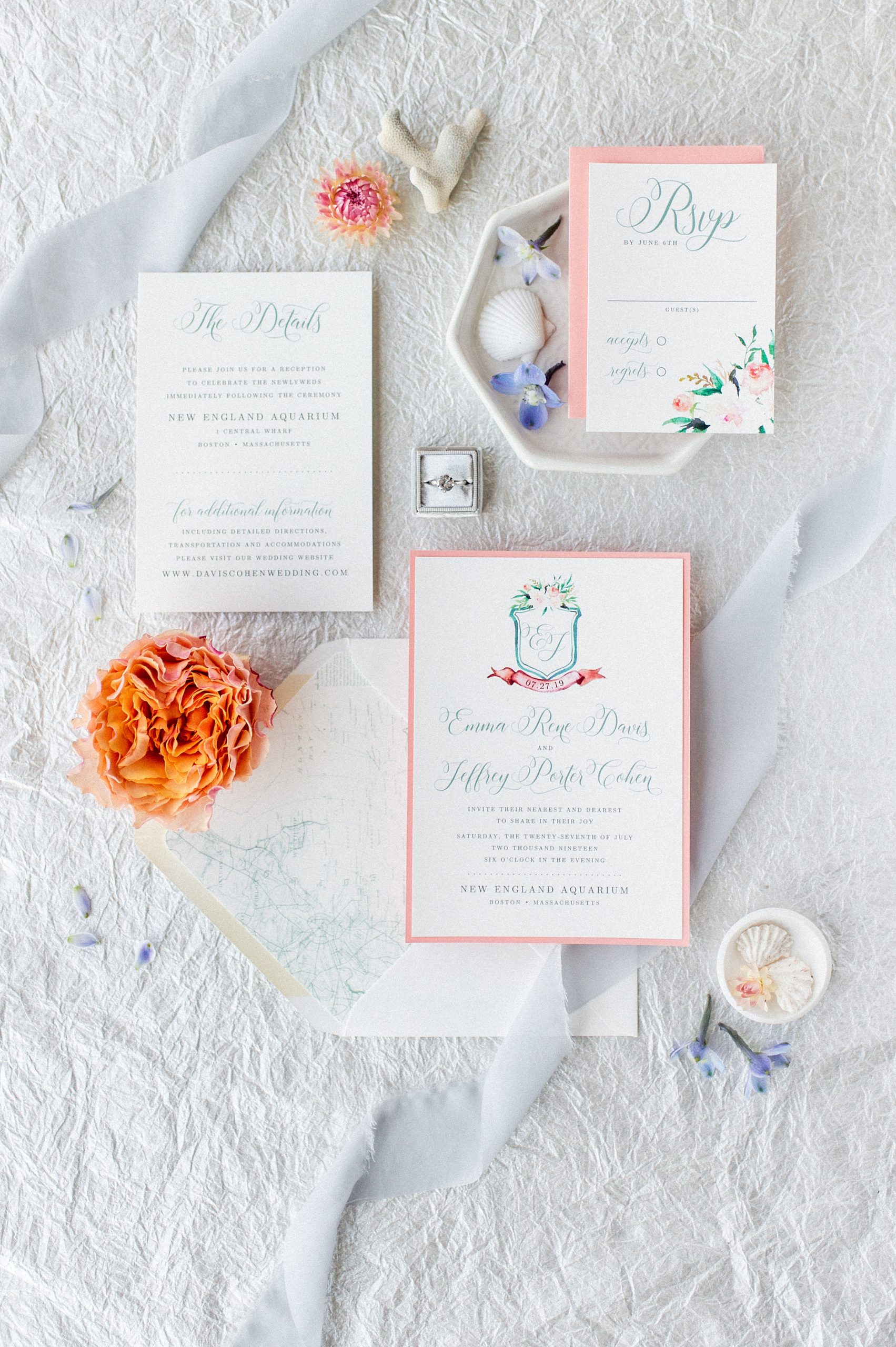 seaside wedding stationery in coral and pale blues with watercolor crest