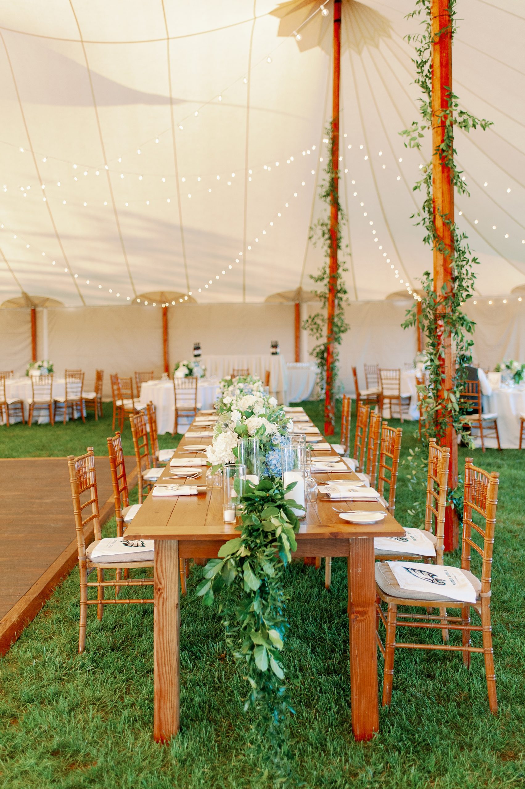 garland and candles on head table for tented weekapaug inn wedding