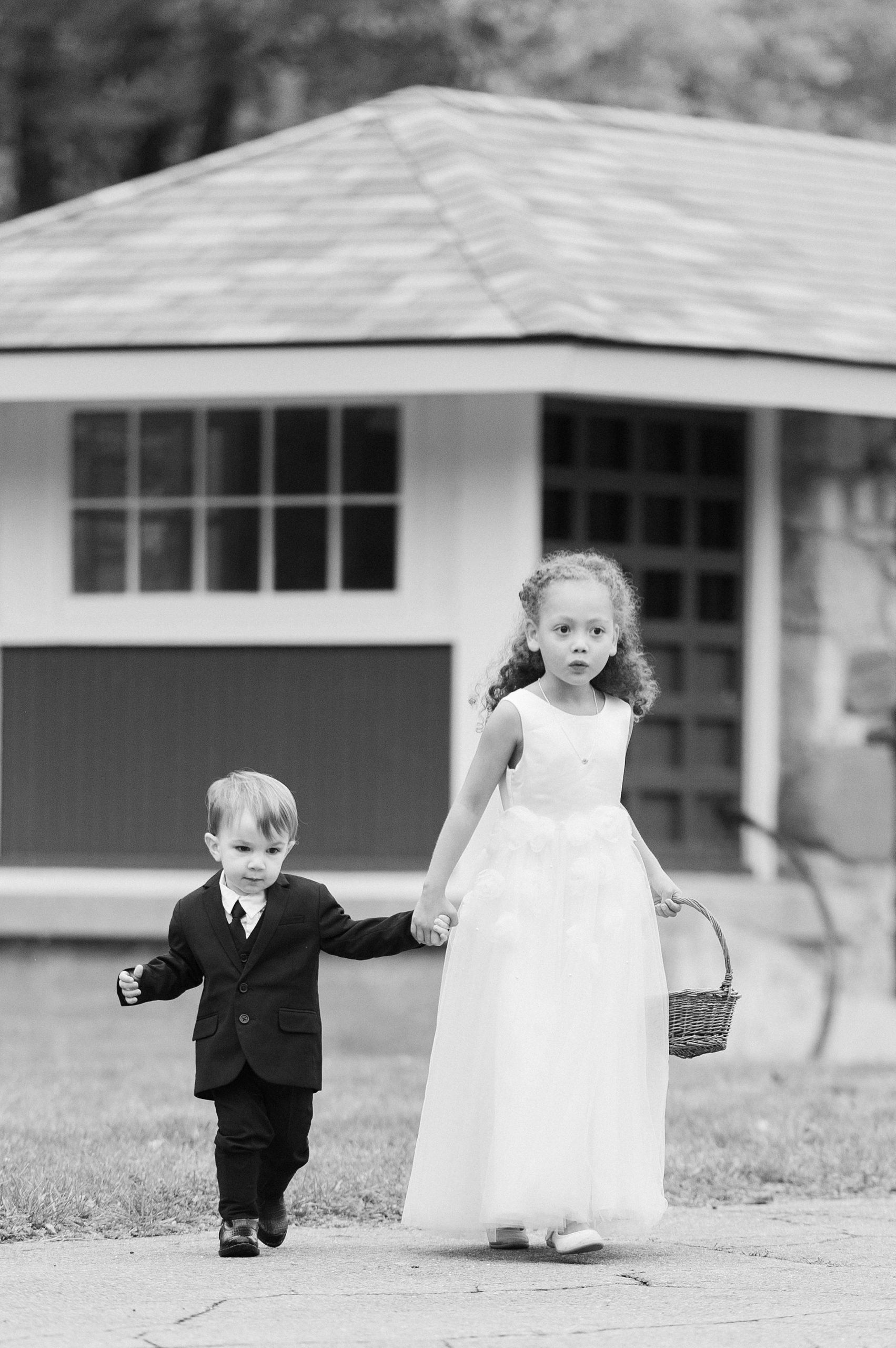 ring bearer and flower girl in black and white at wedding ceremony