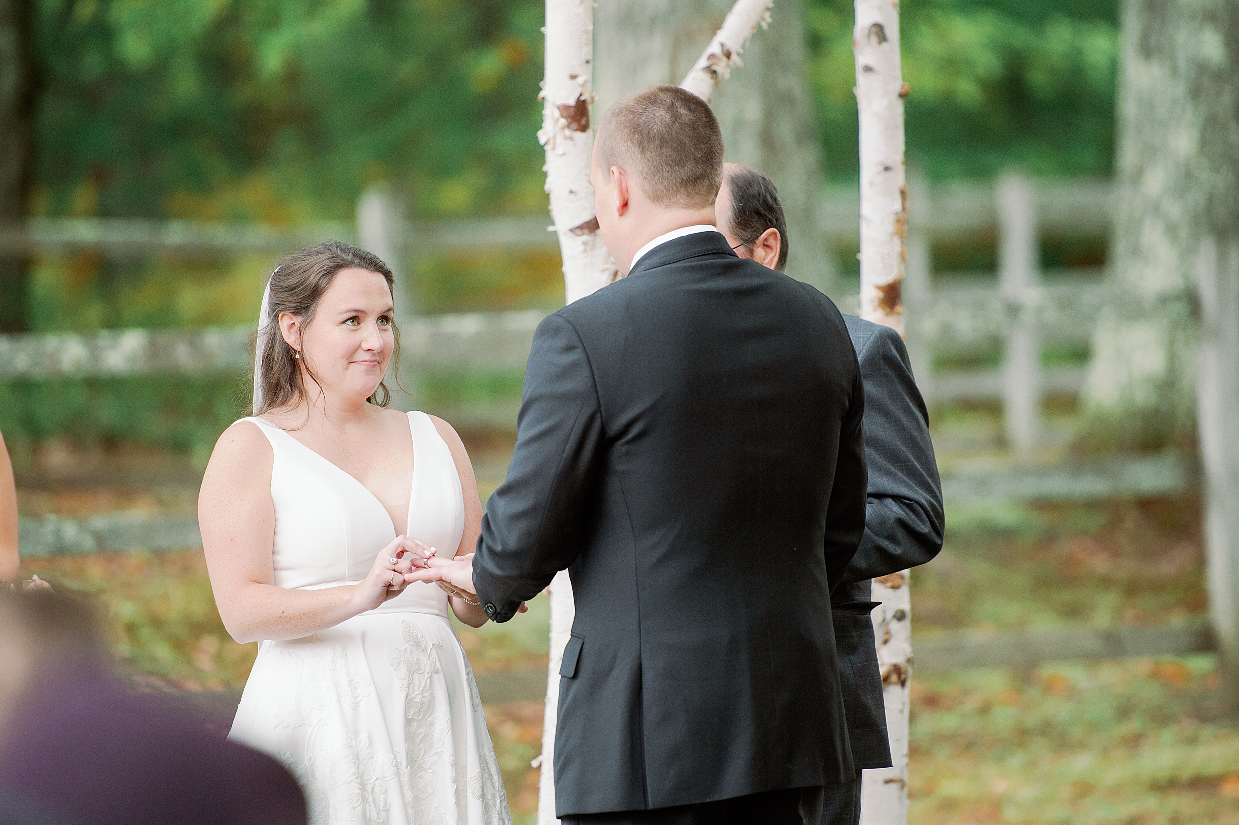 bride and groom exchange rings at The Stone Barn Wedding in Maine