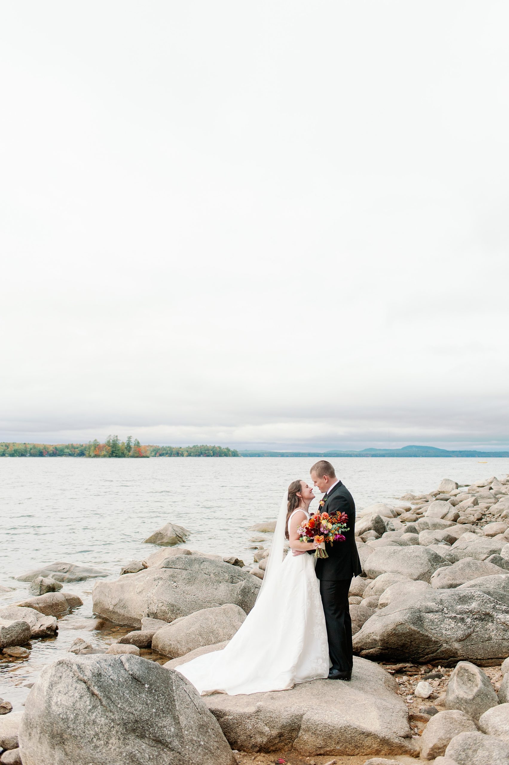 couples portraits on the rocks at Sebago Lake in Maine for Stone Barn wedding