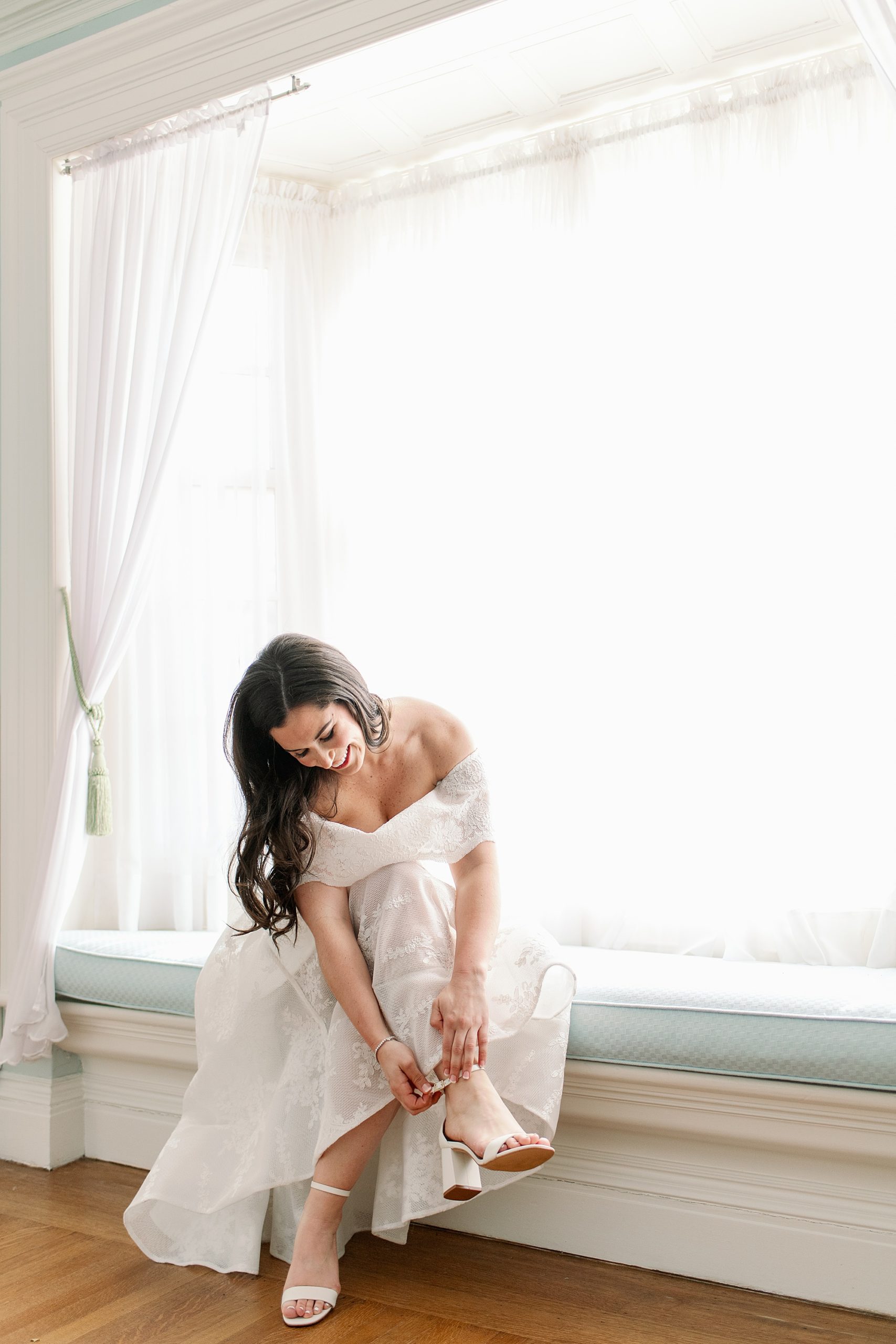 bride puts on shoes for her micro wedding in Massachusetts