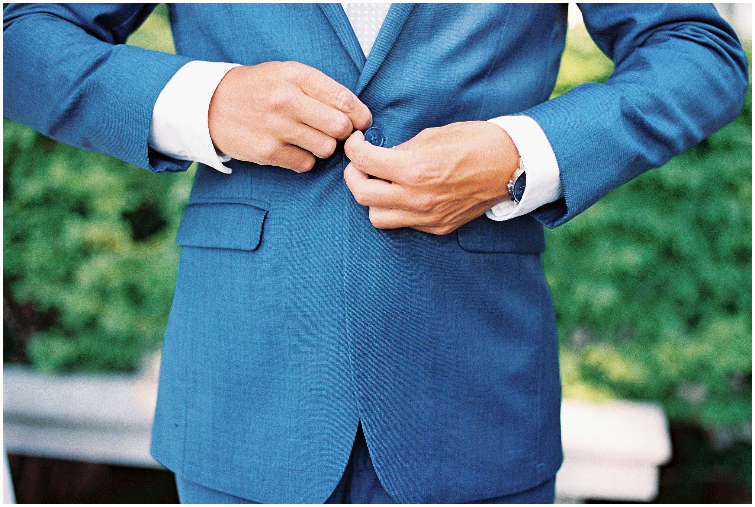 groom in blue suit getting ready for wedding