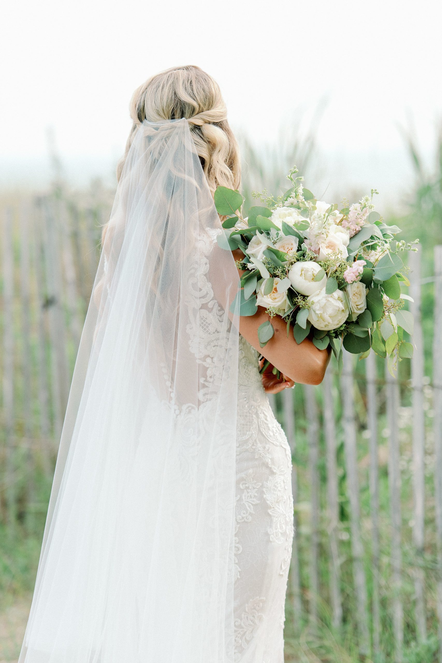 bridal gown and bouquet details with flowing veil