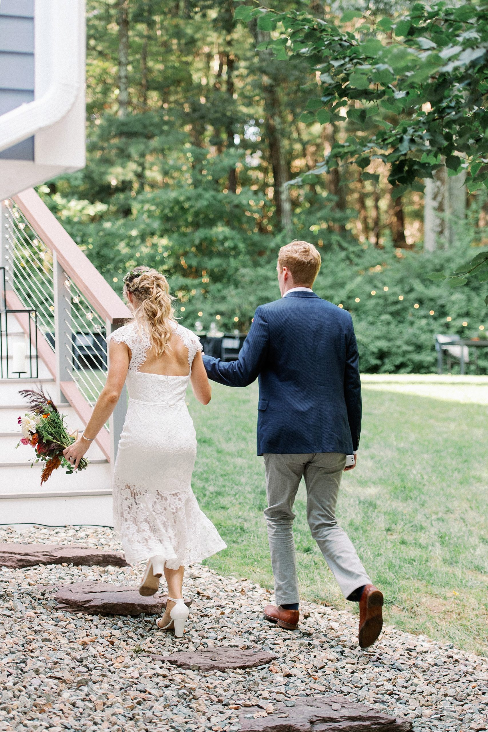 bride and groom walking to reception in backyard at their Massachusetts micro wedding