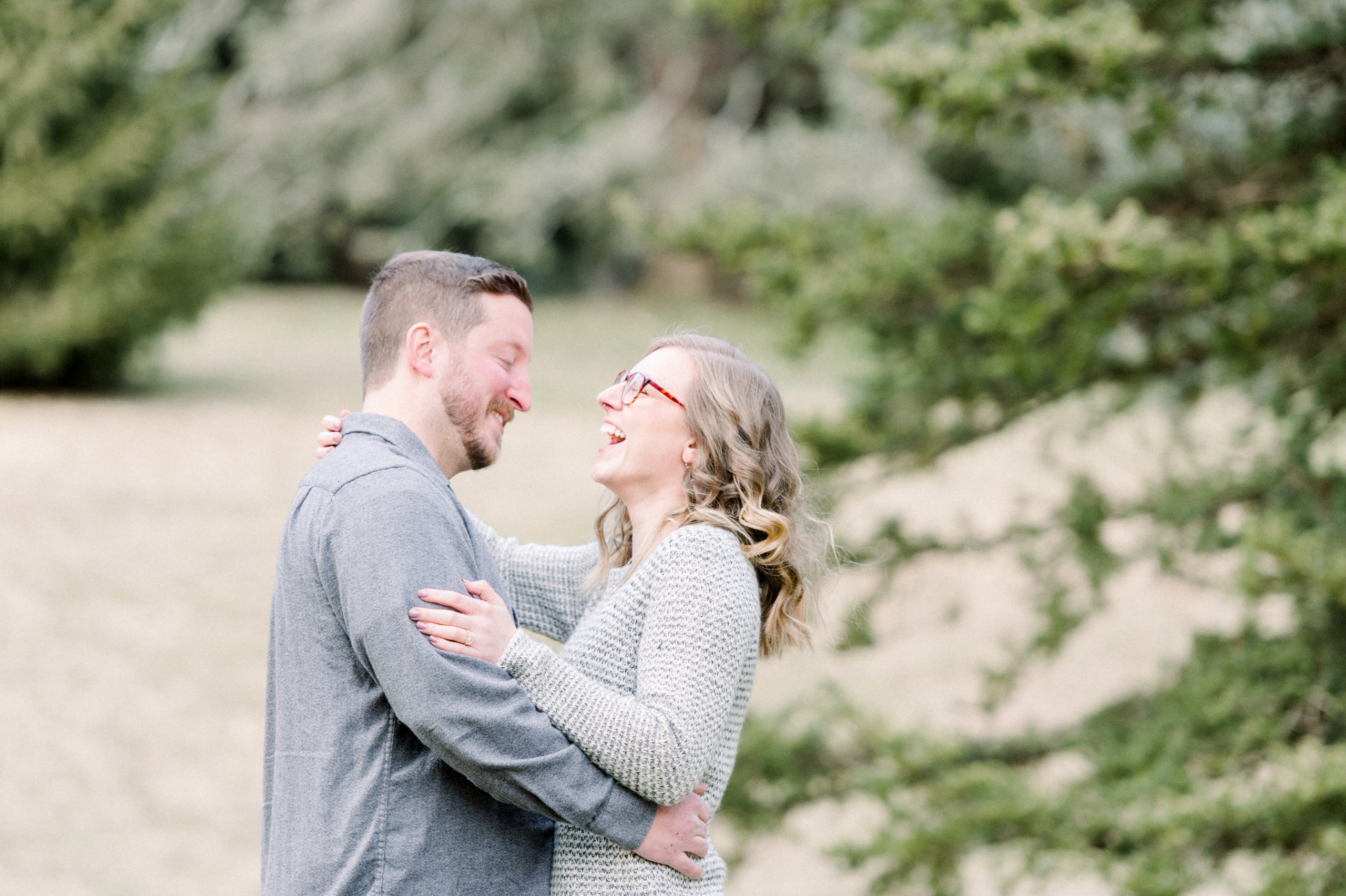 winter engagement session tips couple at arboretum in front of evergreen trees