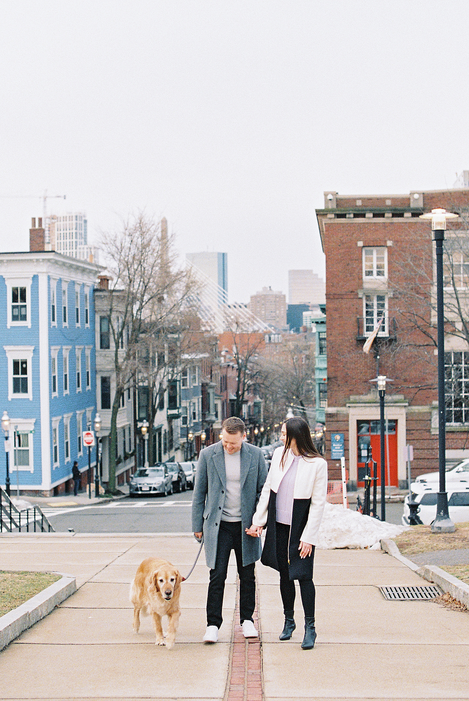 man and woman walking down street for Boston winter engagement session