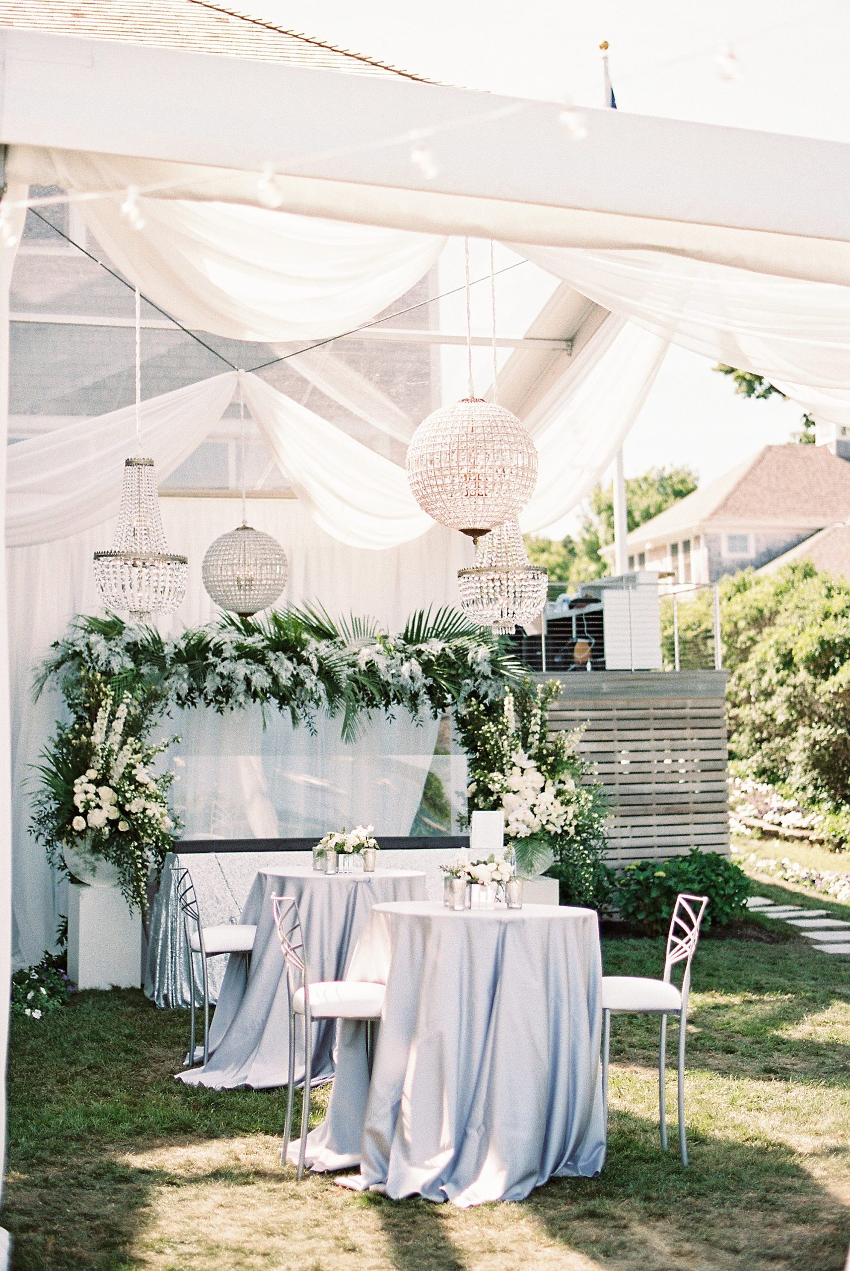 clear tent and chandeliers with lush florals for backyard wedding on Cape Cod by Winstons 