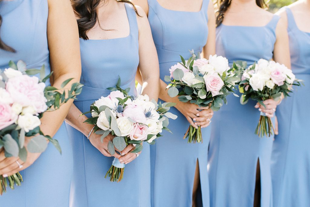 dusty blue dresses and white floral bouquets