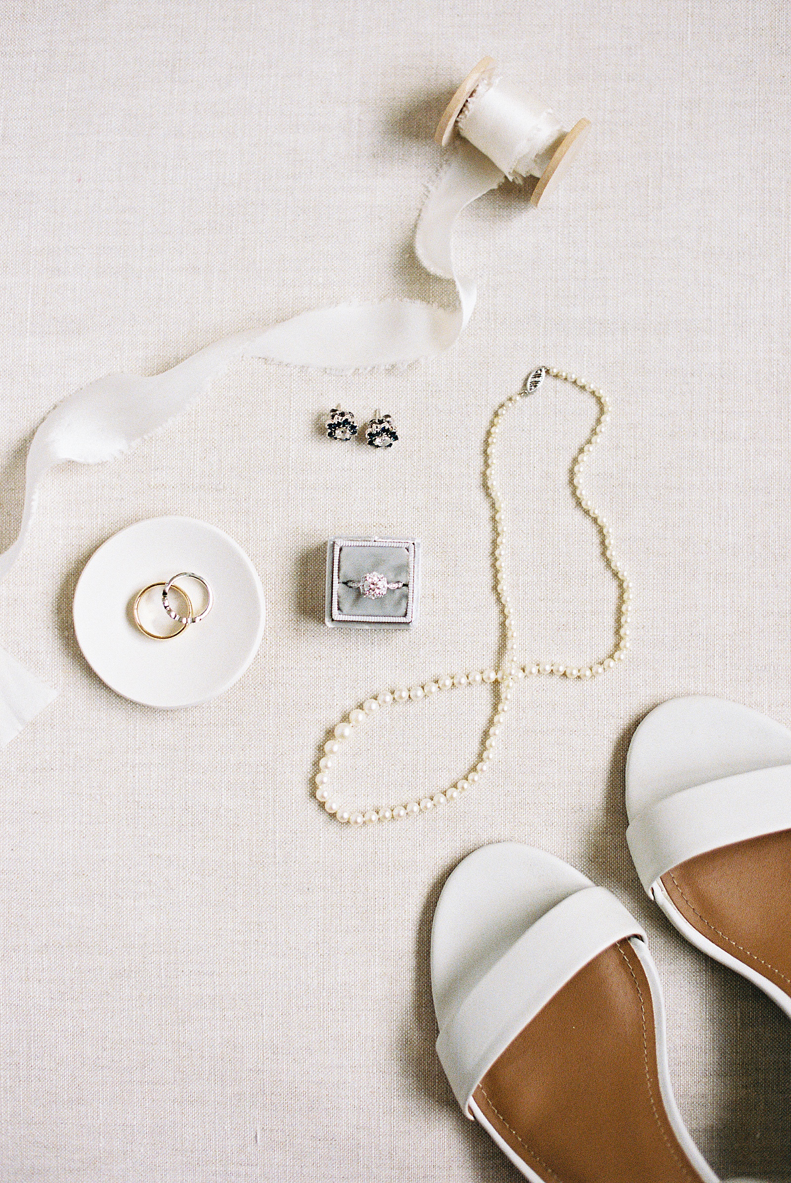 Flat lay of bridal jewelry laid out with shoes. 