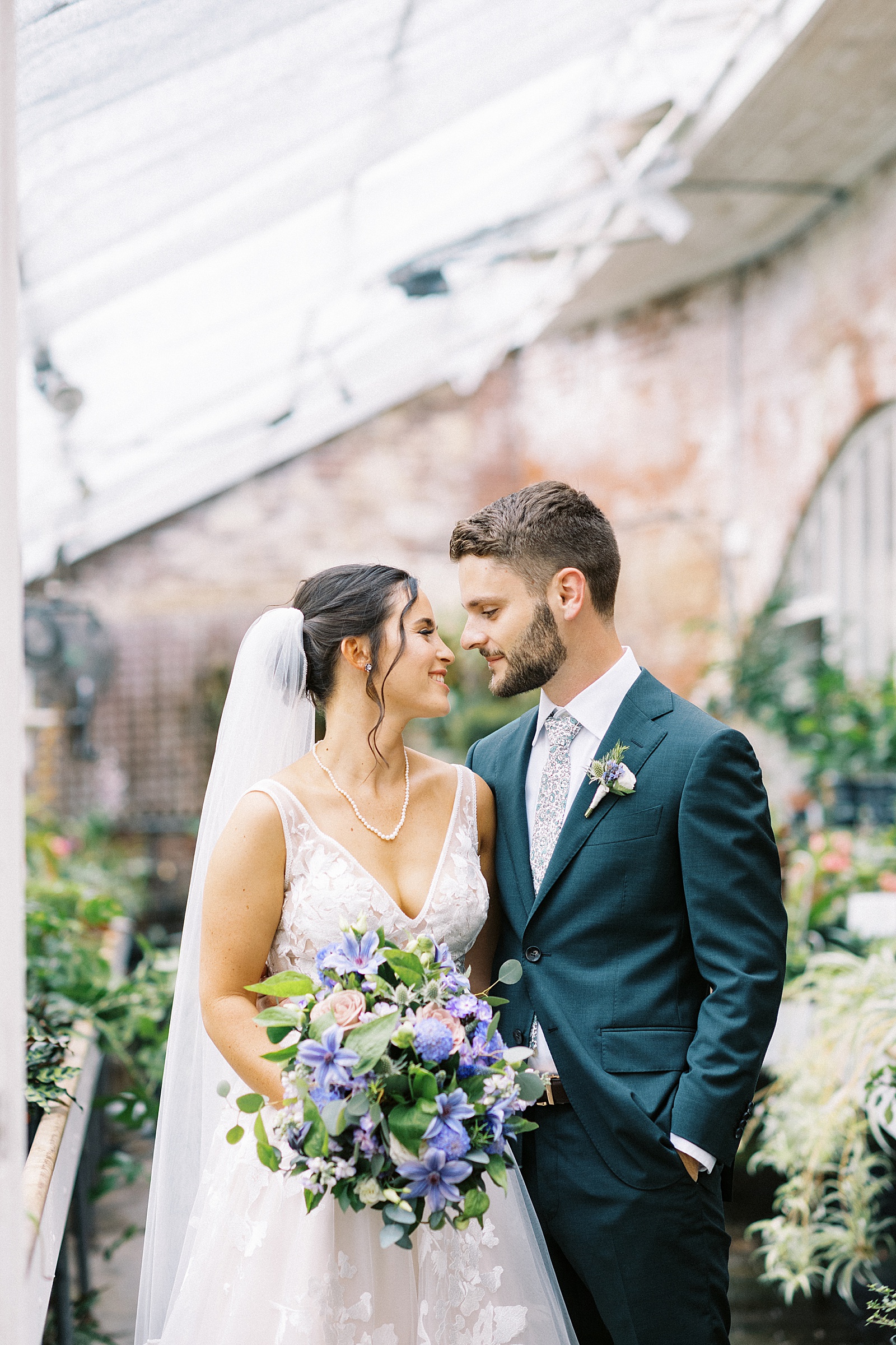 Bride and groom embracing in the greenhouse at the Lyman Estate. 