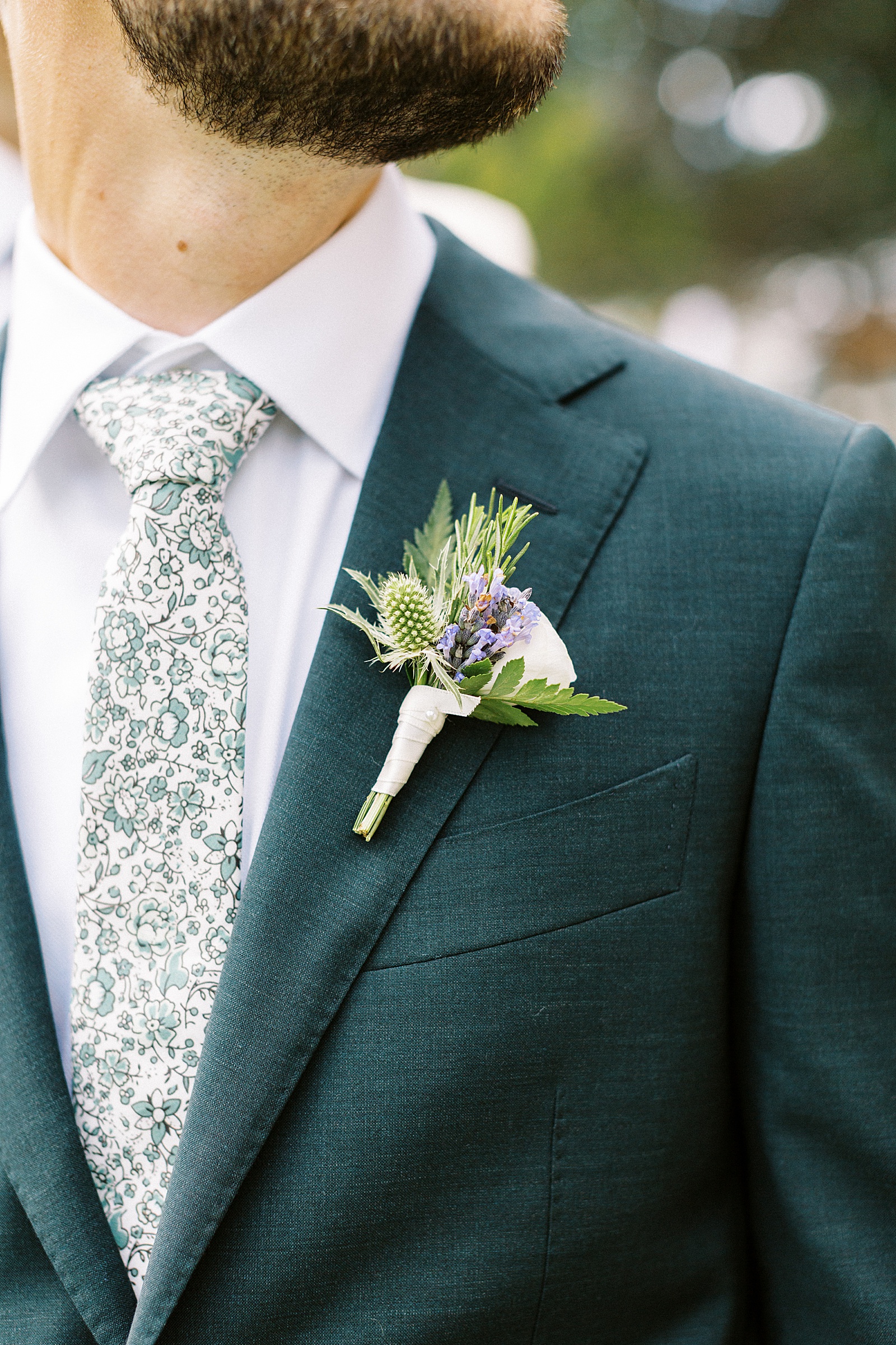 Up close of groom's boutonniere with lavender sprigs in it. 