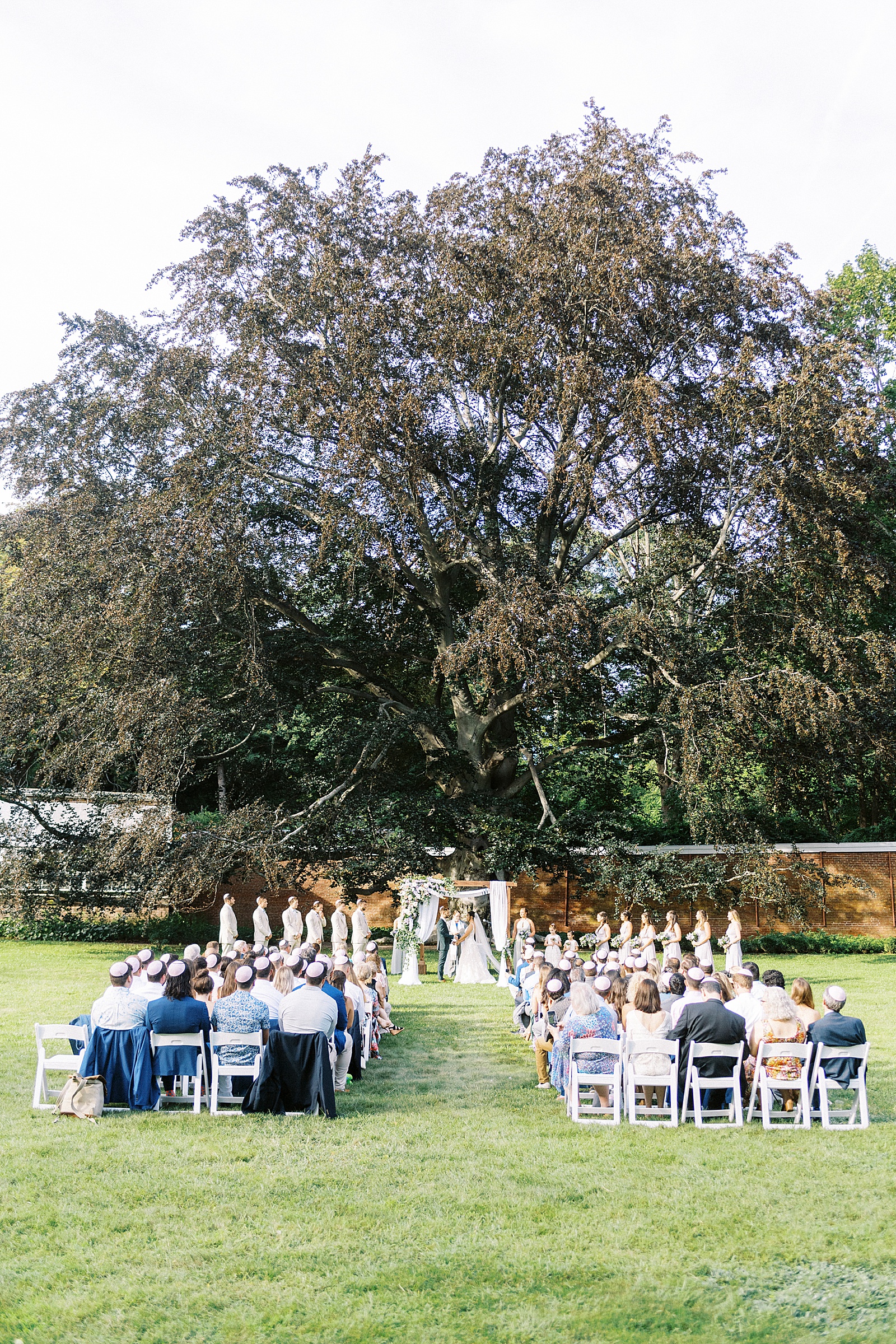 Bride and groom at the alter in front of their guests in the garden at The Lyman Estate. 