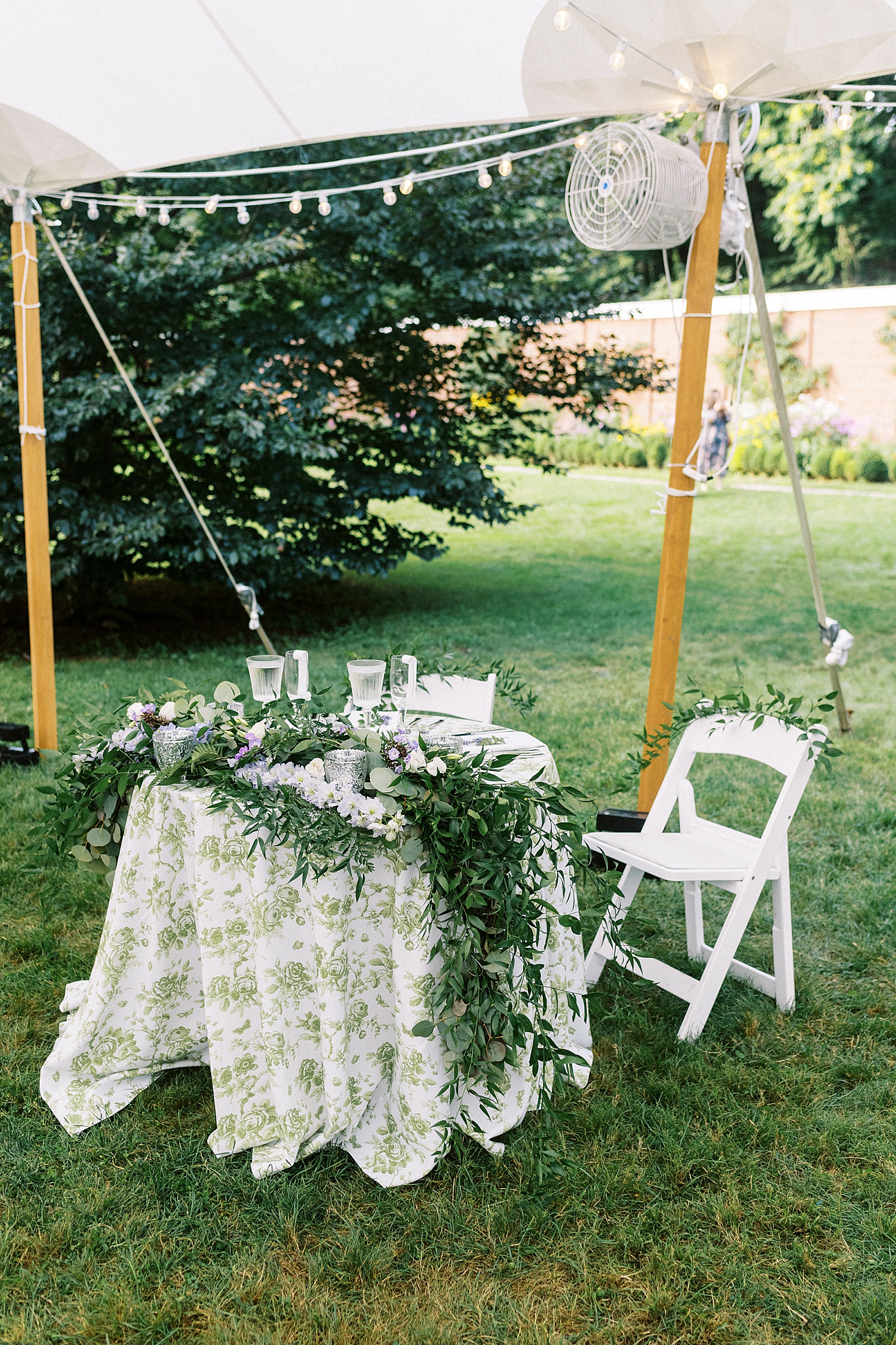 Bride and groom's fully decorated table at their outdoor tented reception at their garden wedding. 
