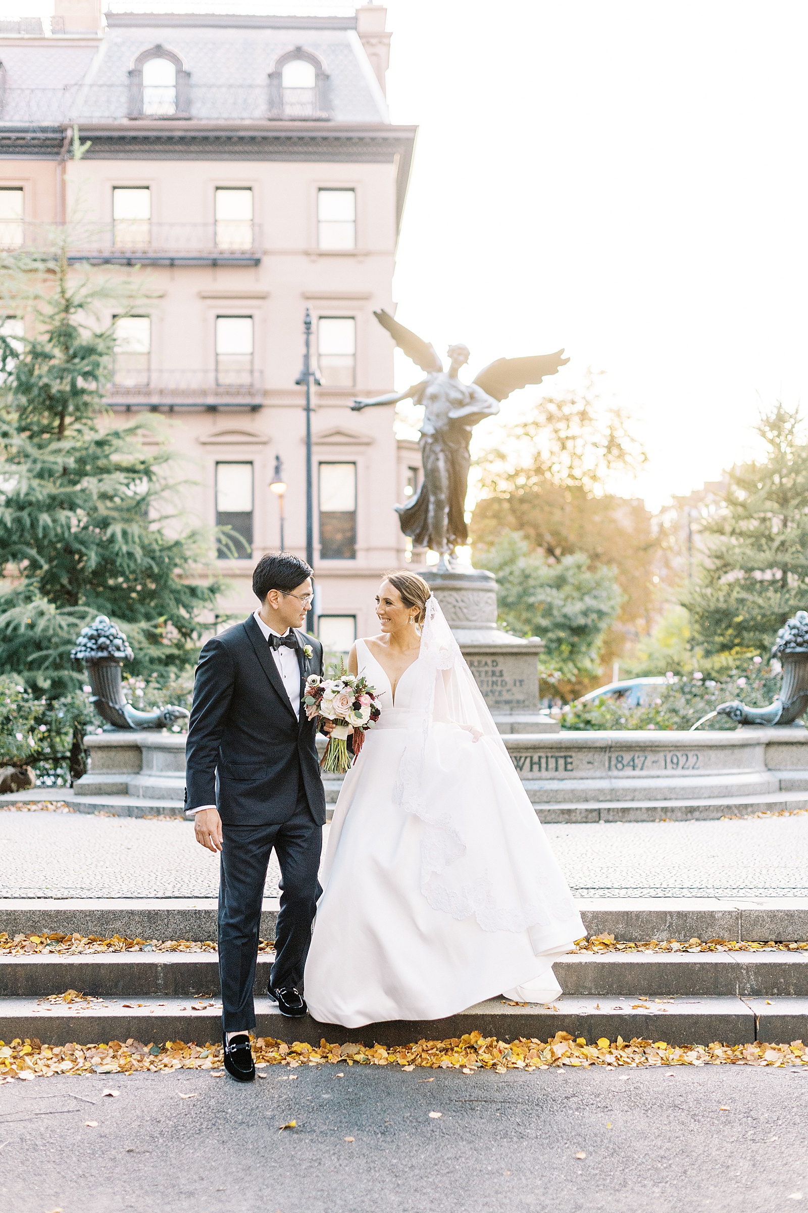 Bride and groom walking down steps in a garden by Boston Wedding Photographer, Lynne Reznick.