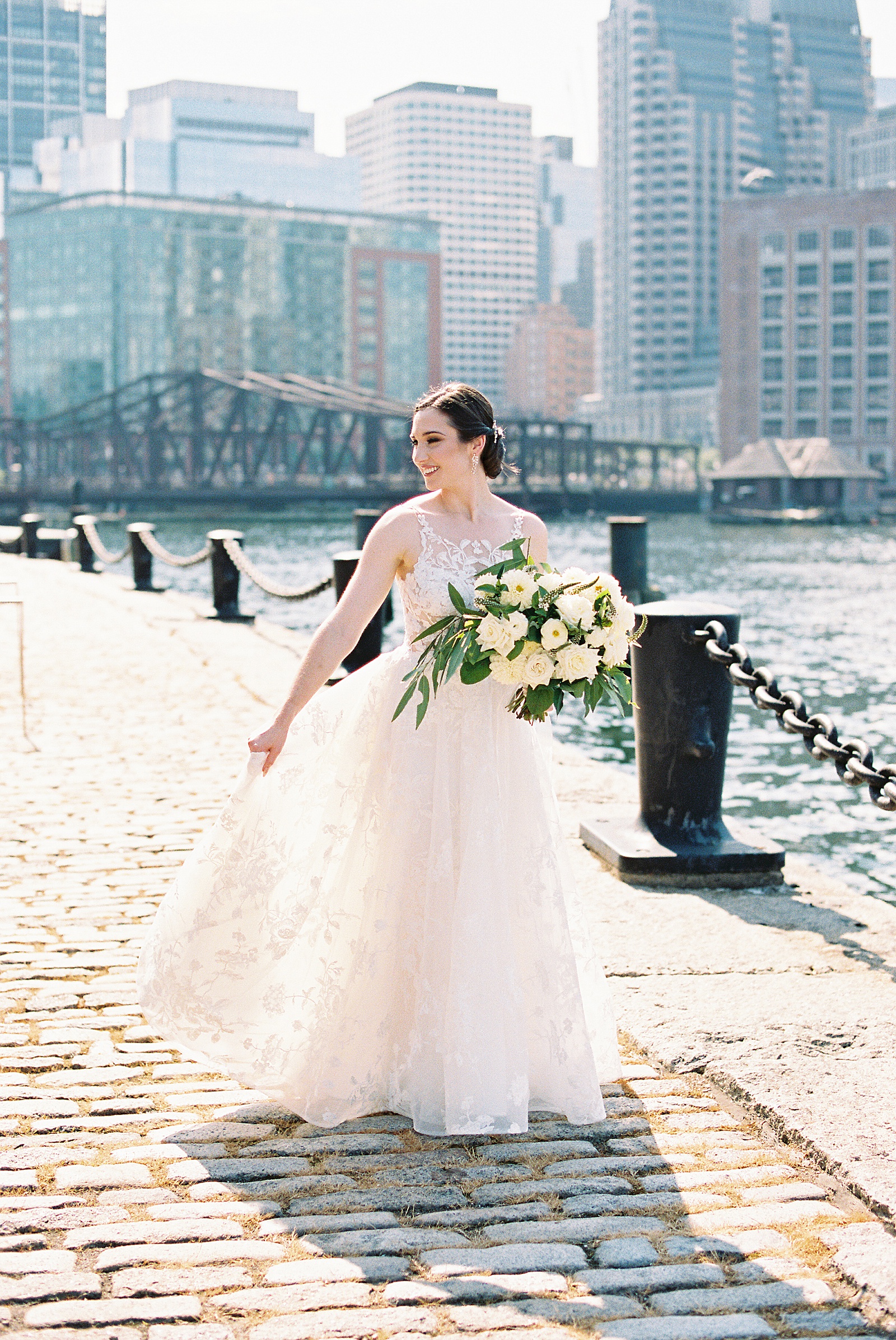 Bride standing on the edge of a river in the middle of a city for a blog post about efficiency strategies. 