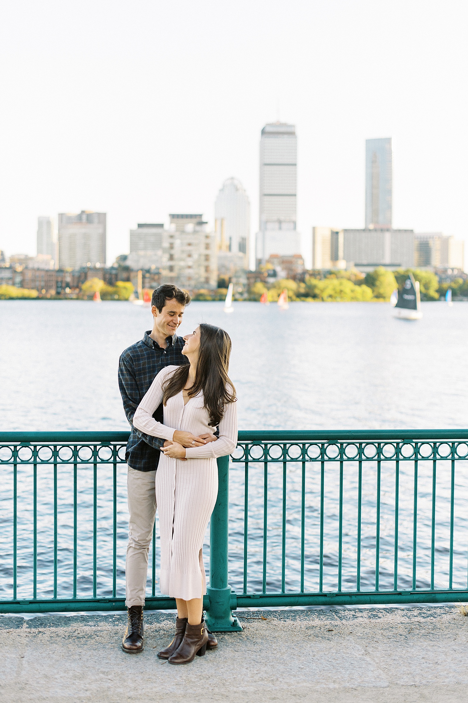 Engaged couple standing by the riverfront for their engagement photo shoot.