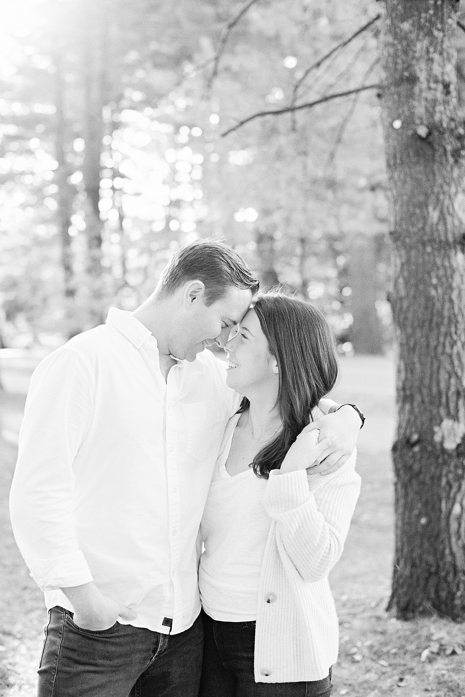 Man and woman embracing in a park for their engagement photos with NY Photographer