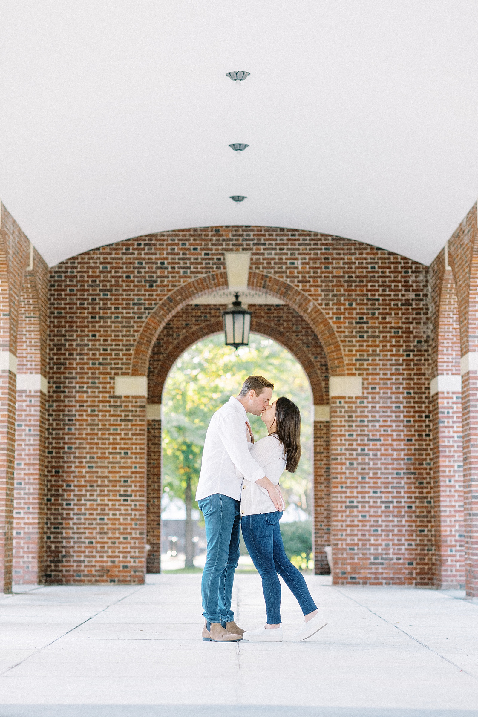 Couple kissing under red brick archways by New York Photographer, Lynne Reznick 