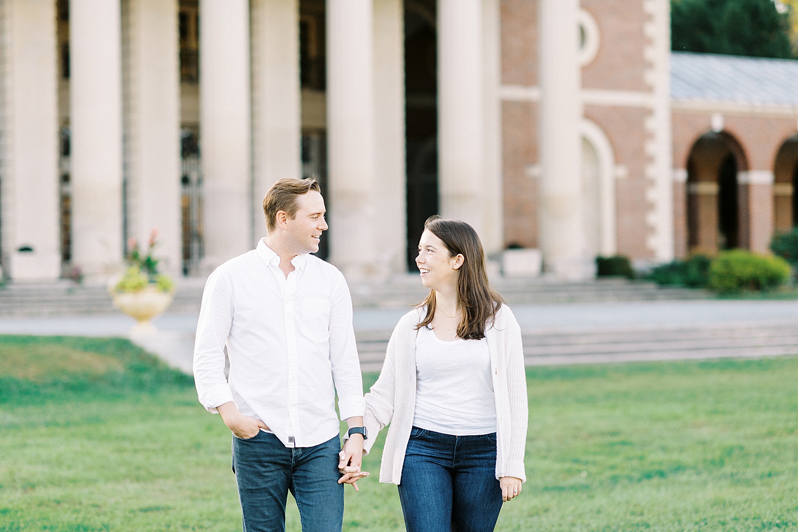 Brunette woman and blonde man in white shirts walk across a New York campus for photo shoot 