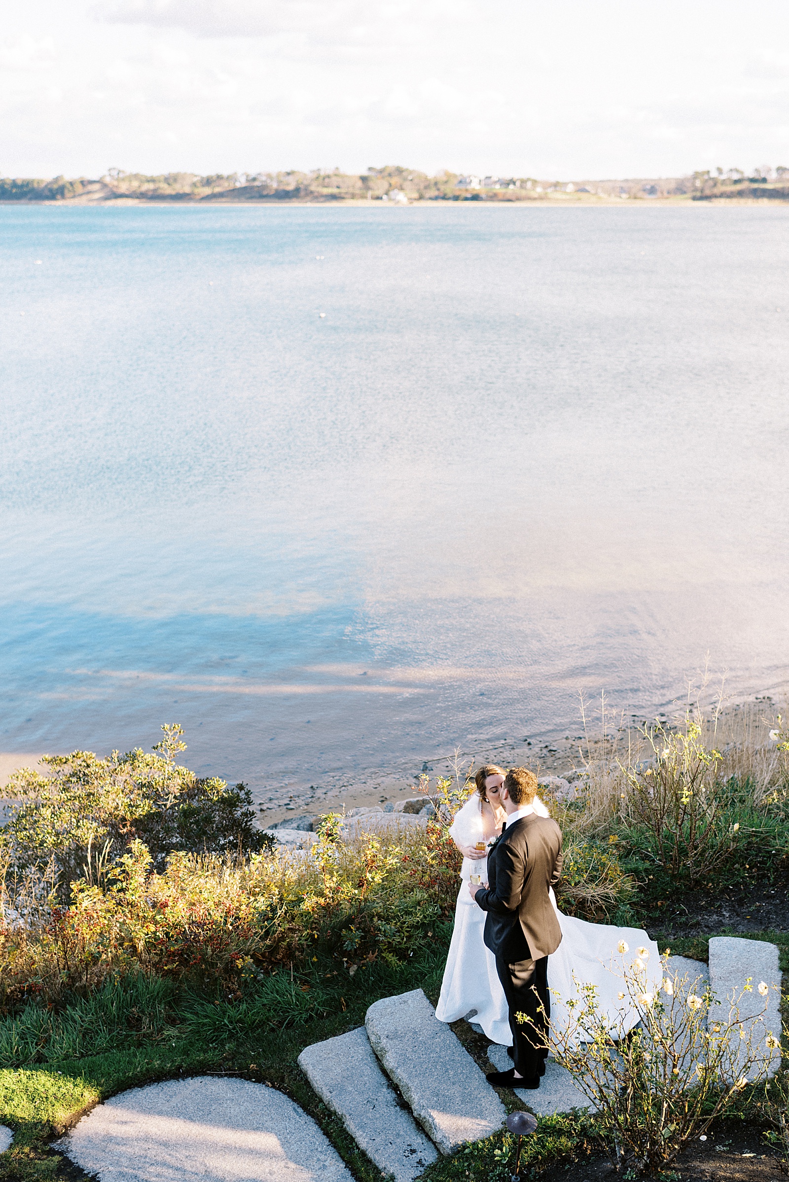 Couple kissing by the ocean on their wedding day by New York Photographer, Lynne Reznick