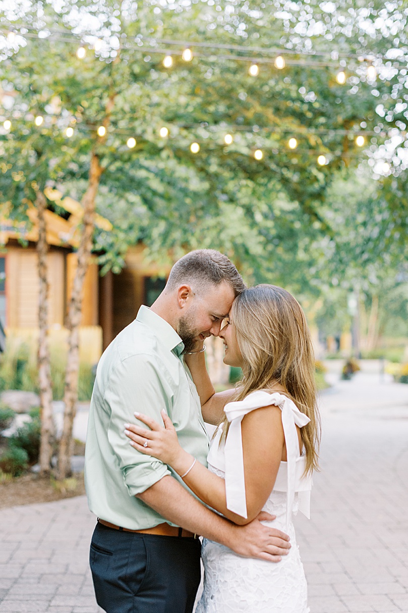 blonde couple embrace under twinkle lights by Boston wedding photographer 