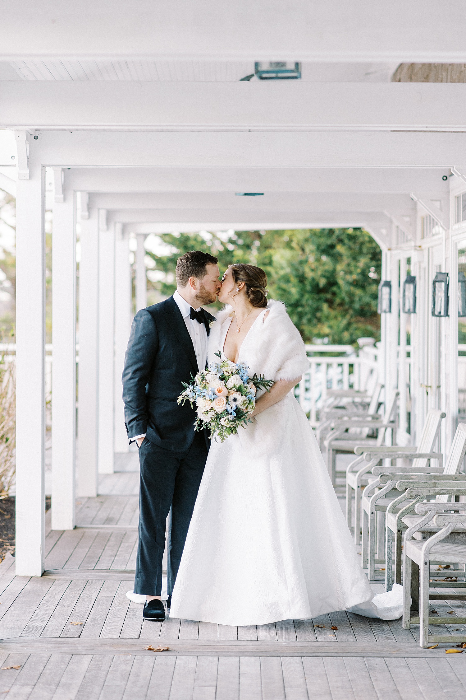 bride and groom kissing on porch after their first look in Cape Cod