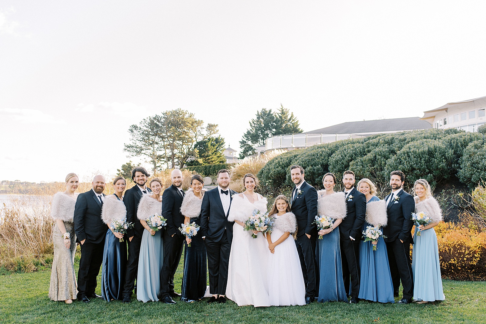 Full wedding party on a lawn in black and blue attire