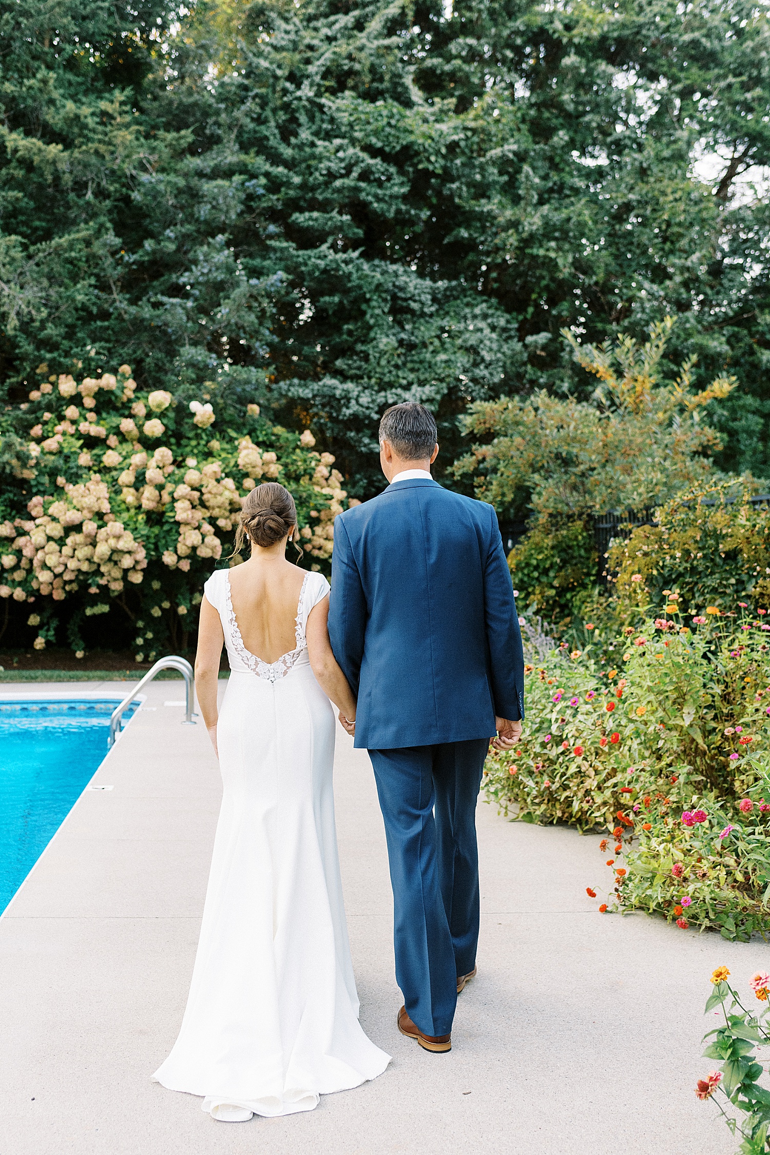 Bride and groom walking next to a pool by Cape Cod wedding photographer Lynne Reznick