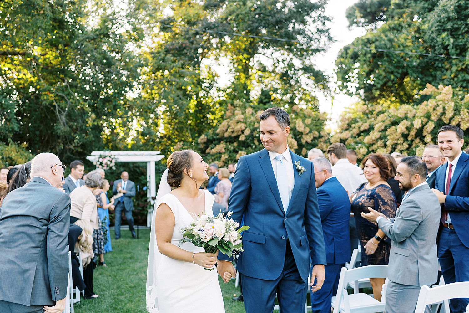 Newlyweds grinning down the aisle by New York wedding photographer Lynne Reznick