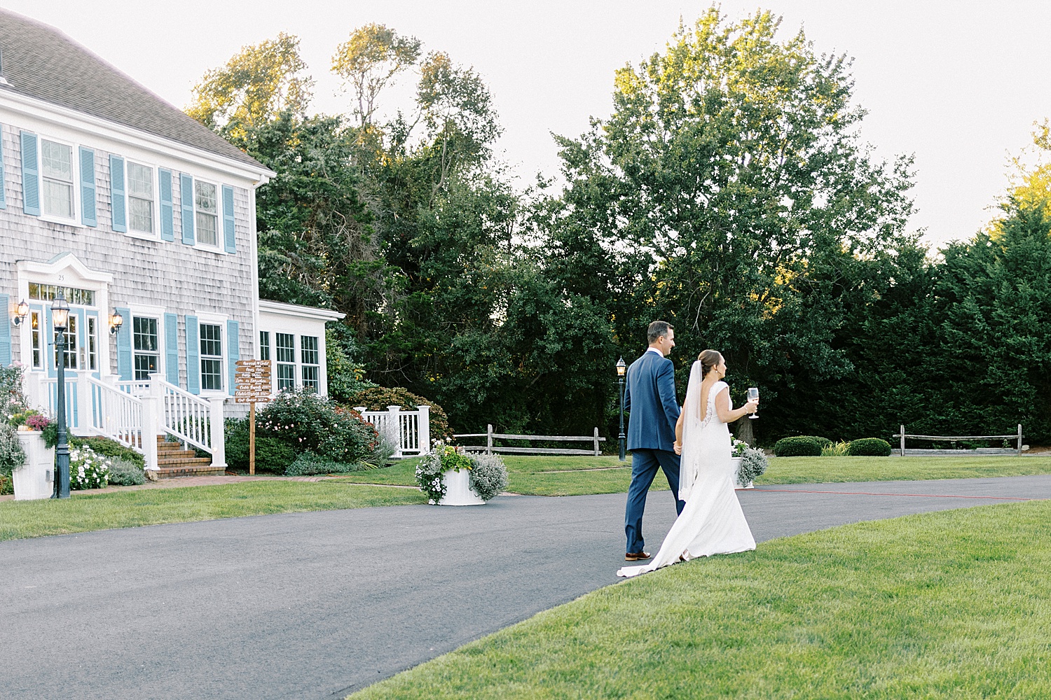 Bride and groom walking next to a house on their way to reception 
