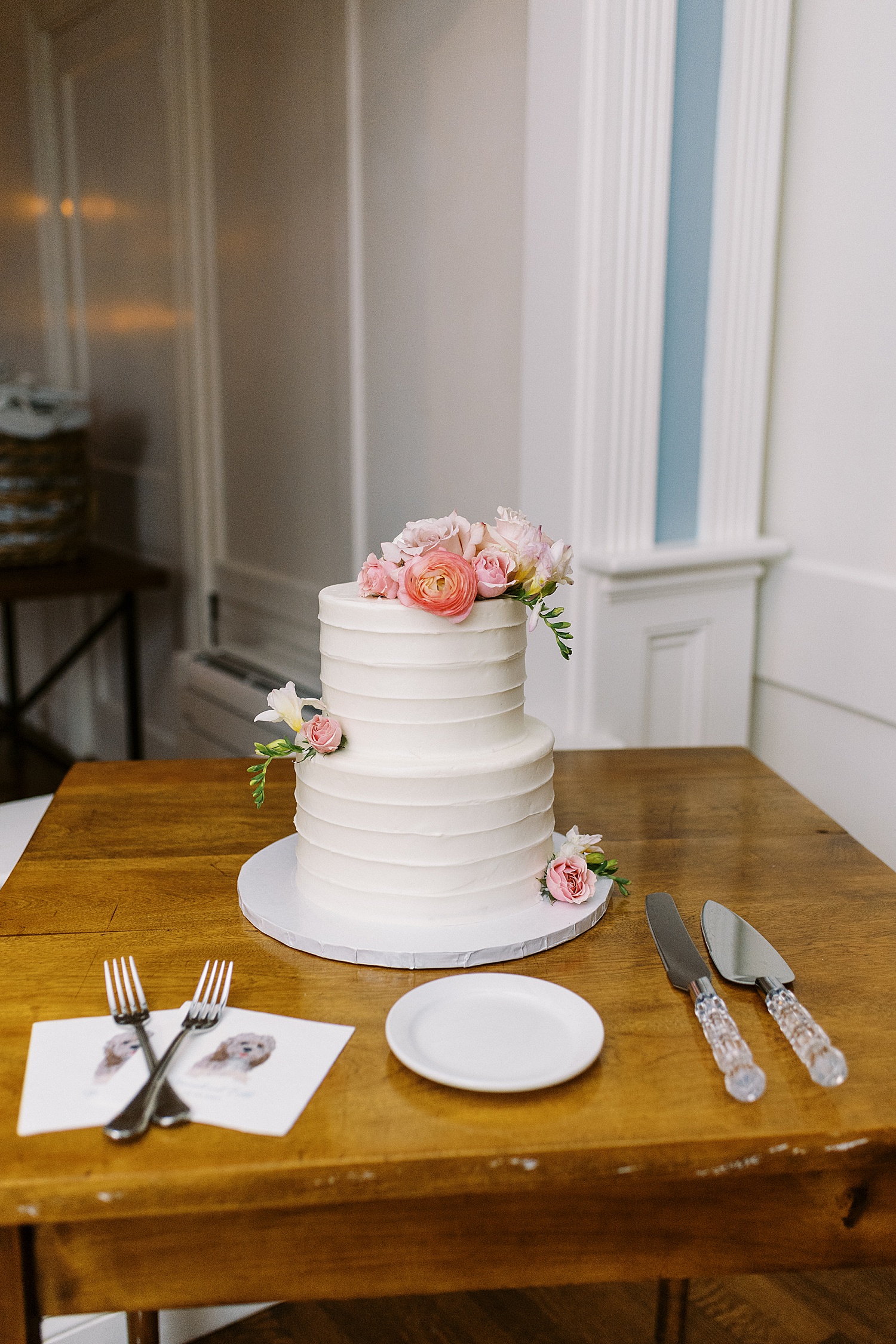Two tier white cake with pink flowers at Dennis Inn Wedding