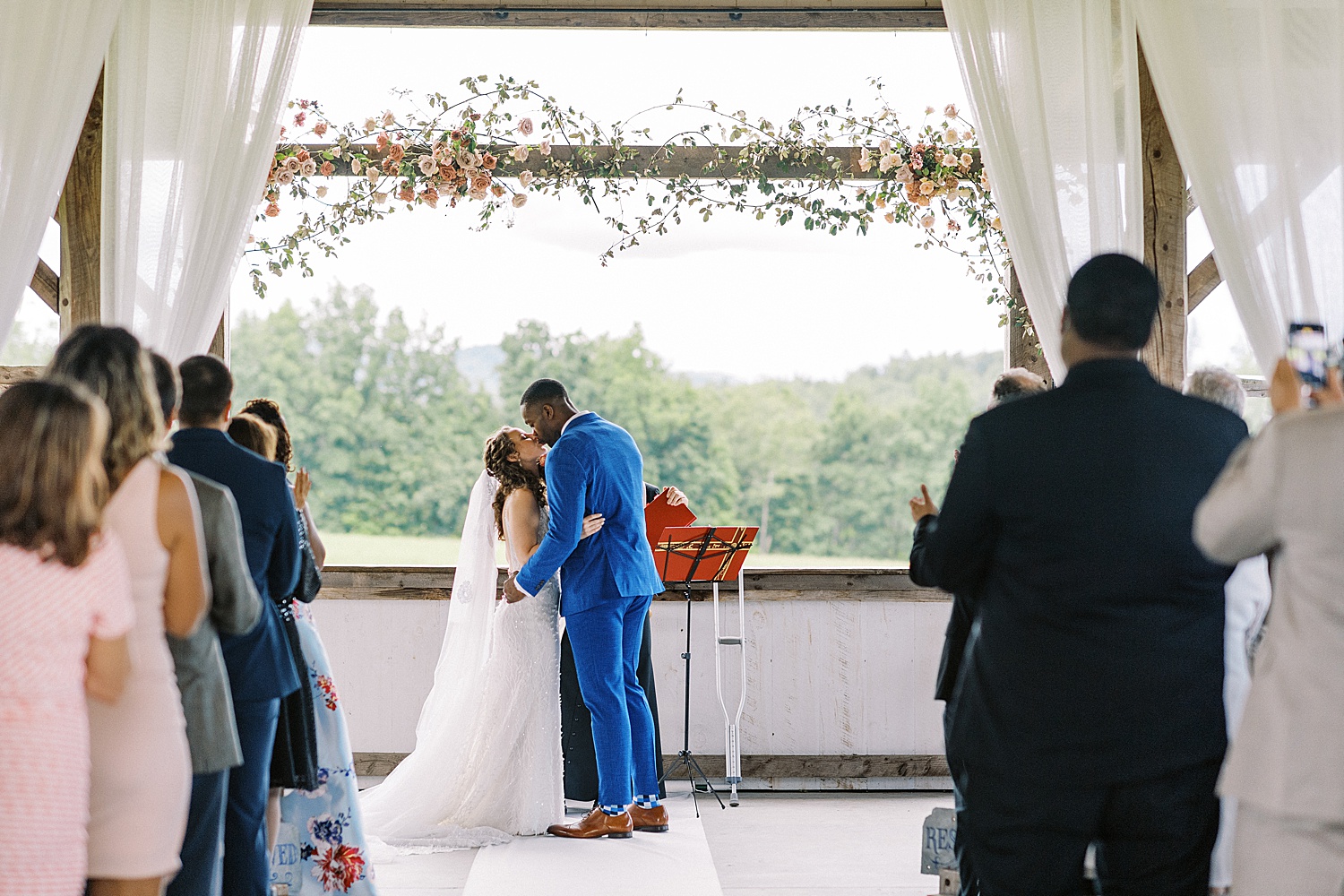 Bride and groom sharing first kiss at alter by Lynne reznick photography