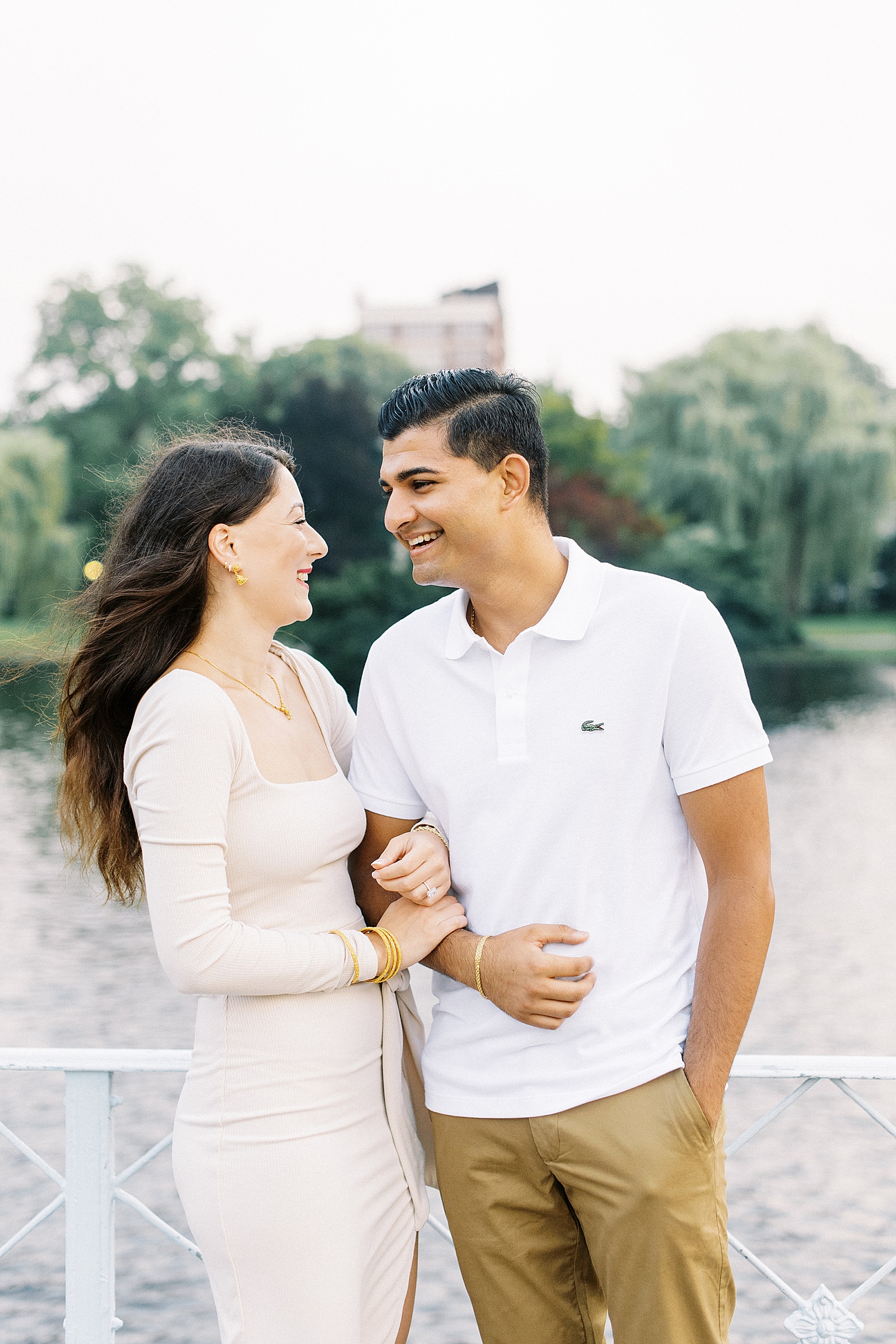Couple in neutral outfits laughing next to pond by Lynne Reznick photography 