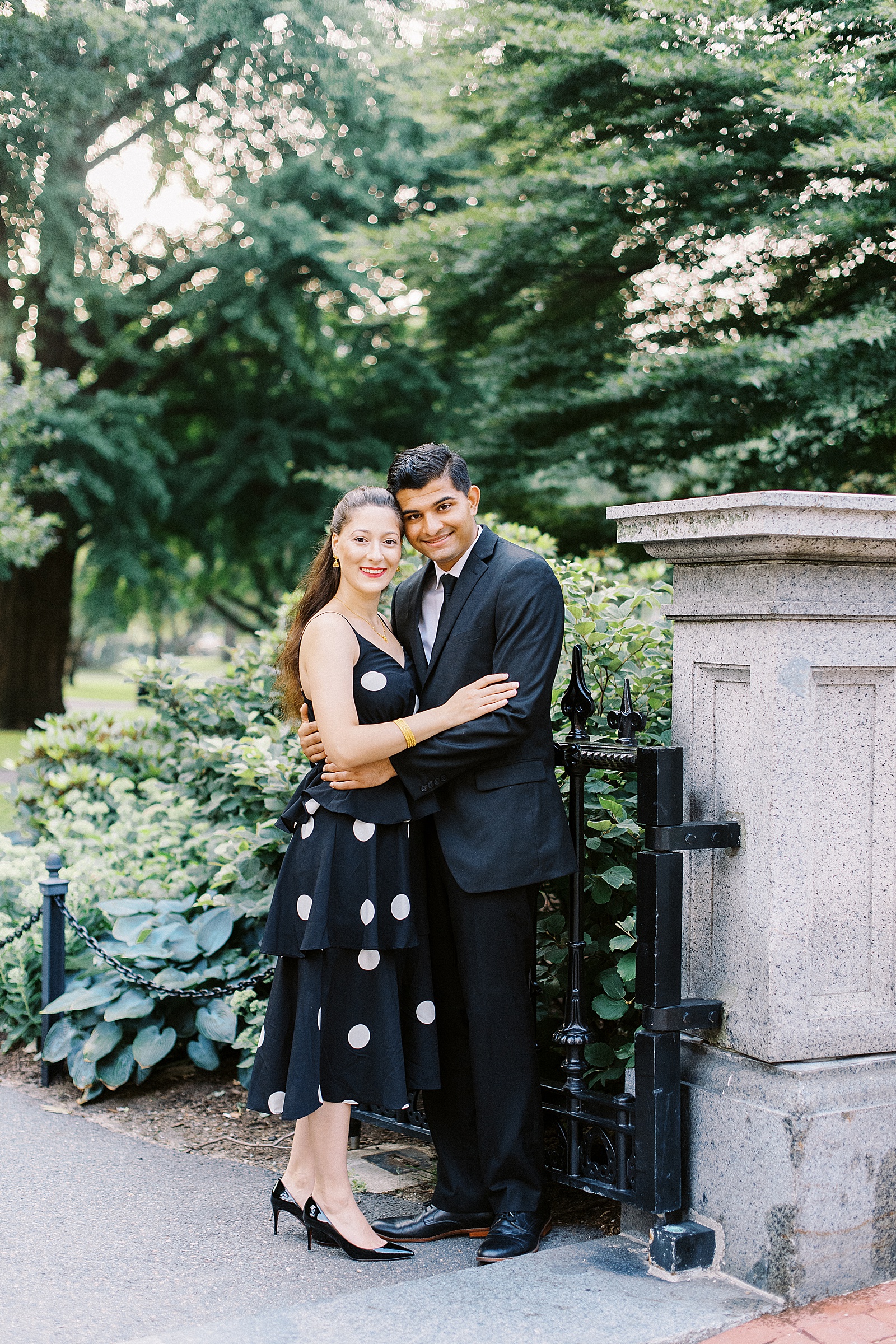 Engaged couple leaning against a garden gate by Lynne Reznick photography 