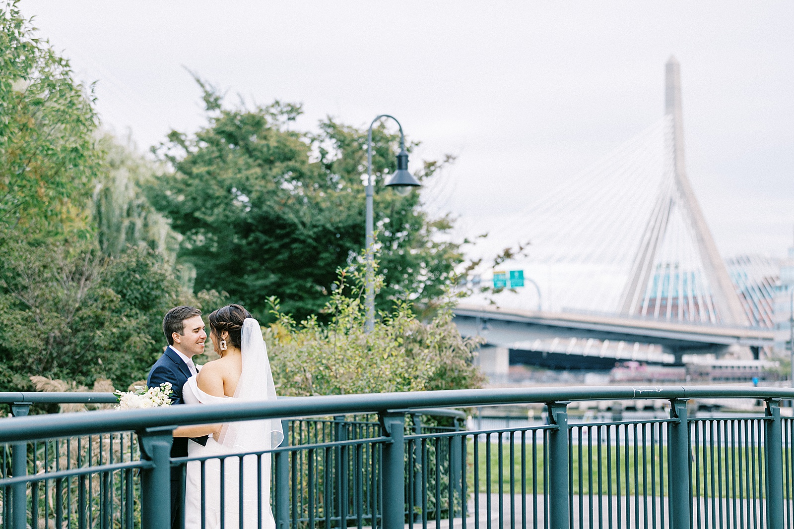couple kissing by a bridge