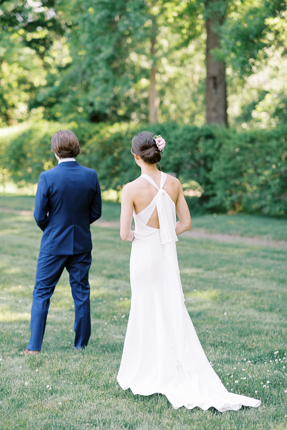 bride in modern elegant gown walks up to groom for first look before Glen Magna farms wedding