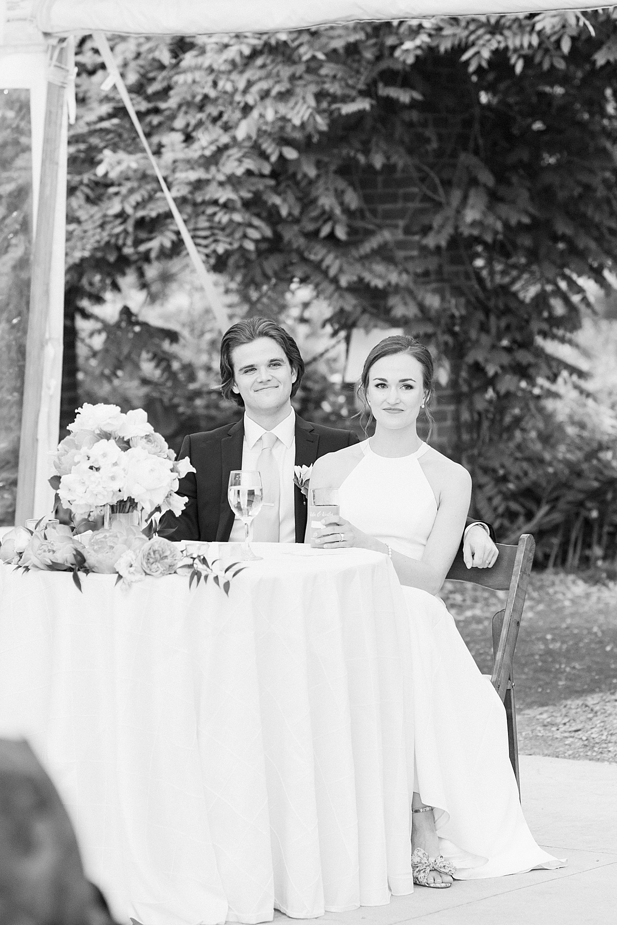bride and groom listen to toasts in garden tent reception shot by Massachusetts wedding photographer