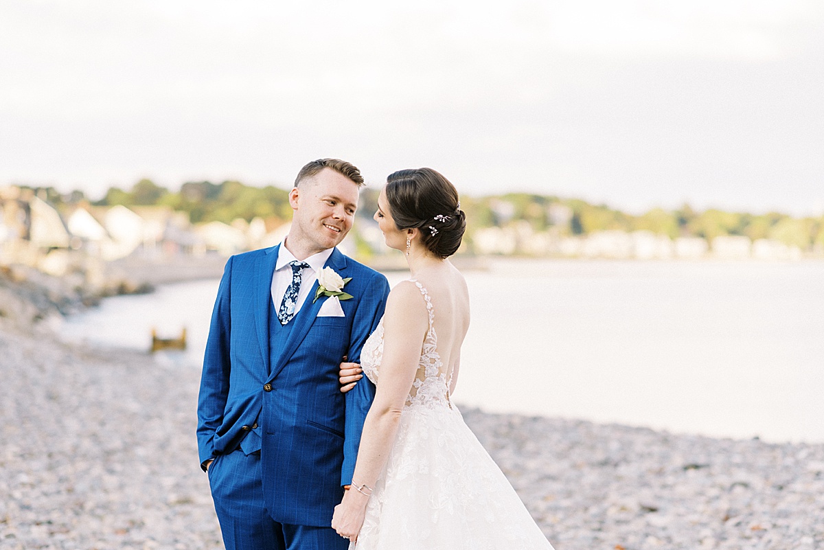 bride in lace gown and groom in blue suit pose for portraits with Lynne Reznick Photography